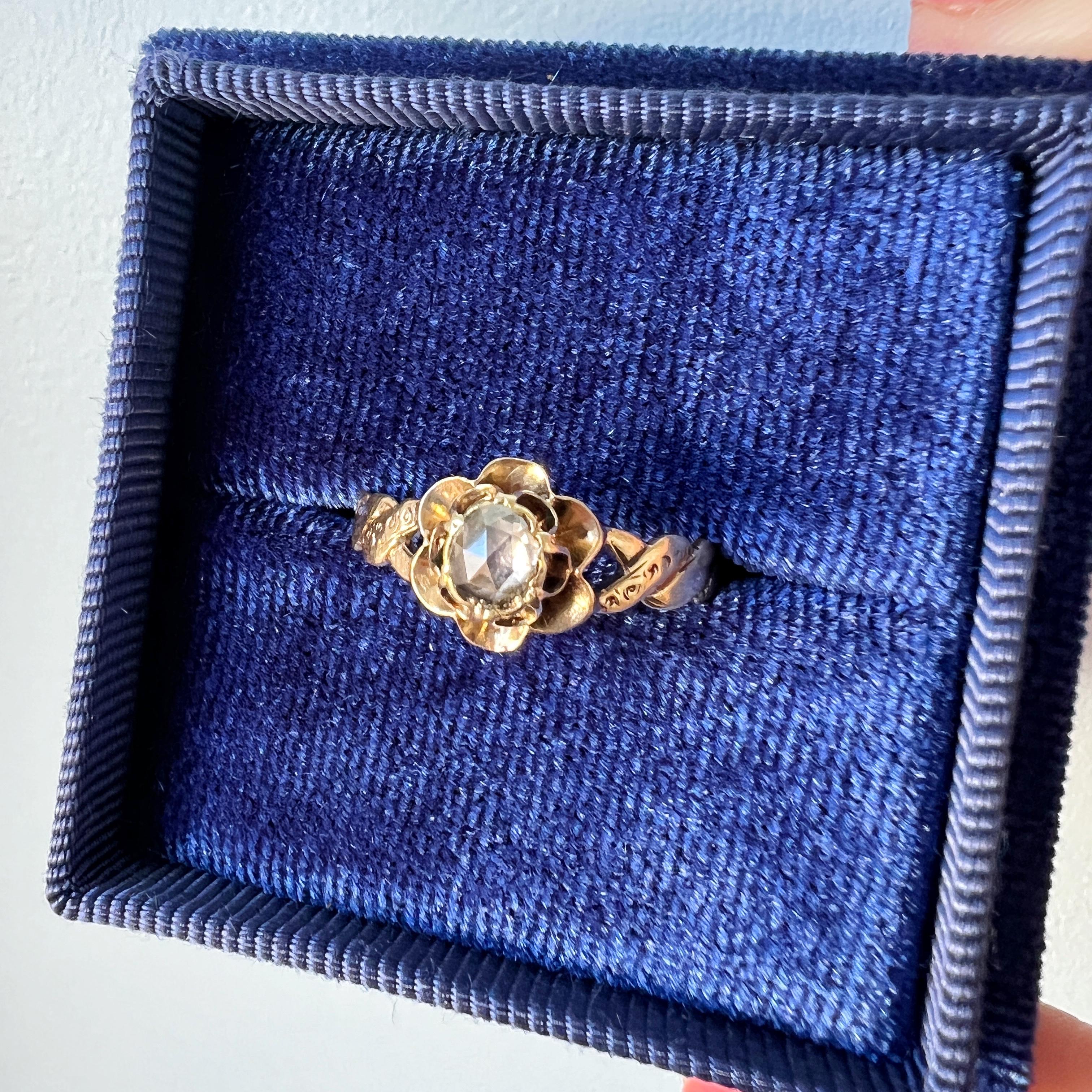 For sale a Victorian era 18K gold rose flower ring – a timeless testament to the romance of a bygone era.

At the heart of this ring lies a radiant rose cut diamond, measuring a dainty 4mm in diameter, with an estimated weight of approximately 0.2