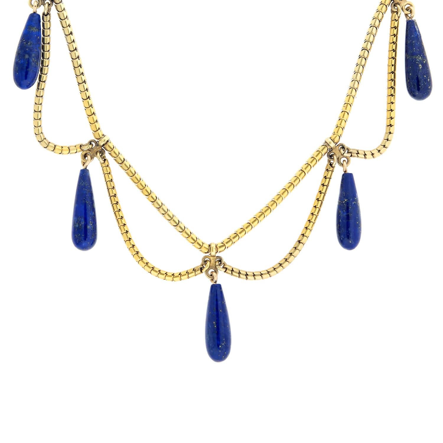 A lovely necklace from the Victorian (ca1880s) era! Crafted in 18k yellow gold, this classically designed necklace features five beautiful dark blue and brown speckled lapis lazuli teardrop dangles. The necklace is composed of a snake chain riveted