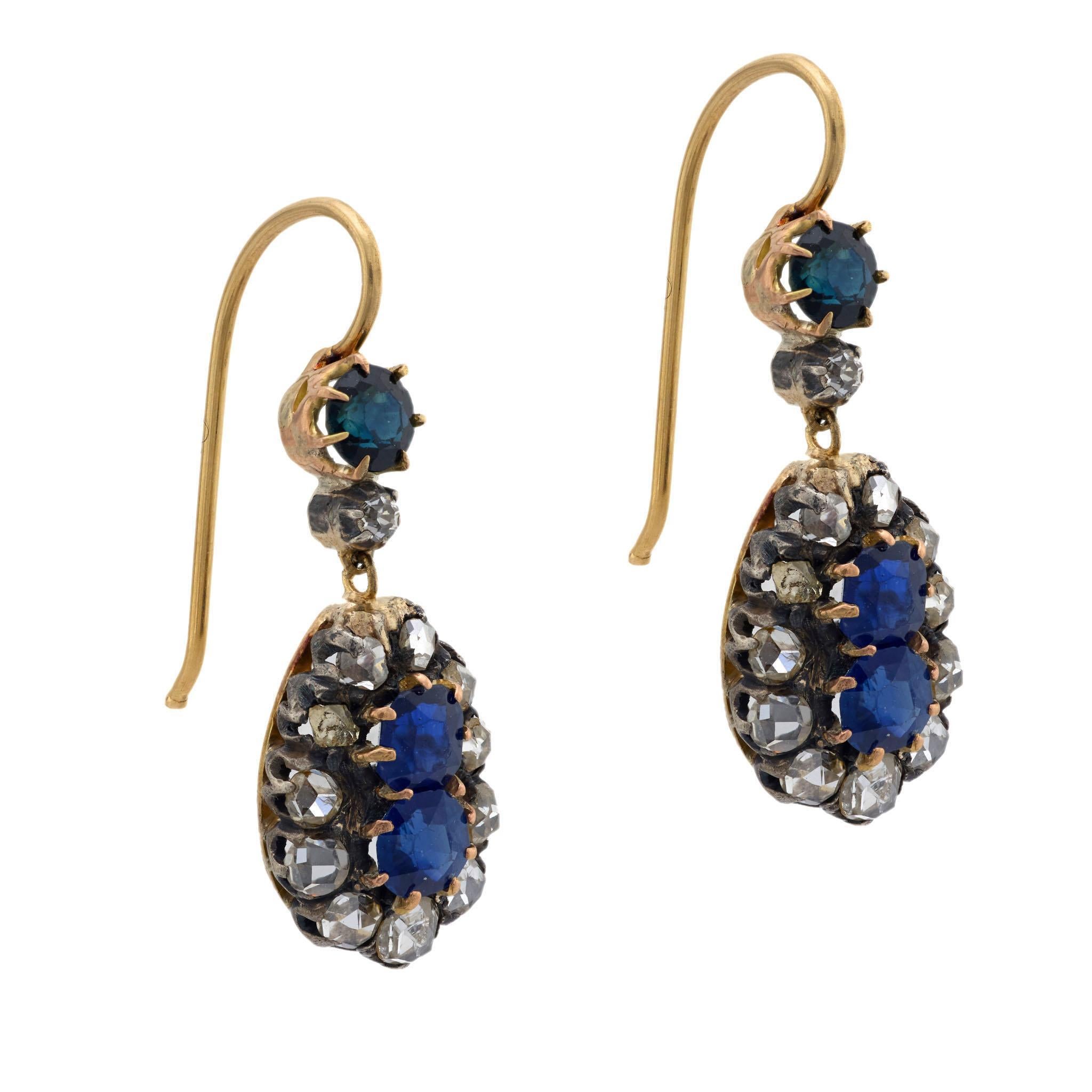 A breathtaking pair of sapphire and diamond earrings from the Victorian (ca1880s) era! Crafted in 18k yellow gold and sterling silver, the earrings begin with a simple surmount. The surmount features a prong-set round cut sapphire, which rests above