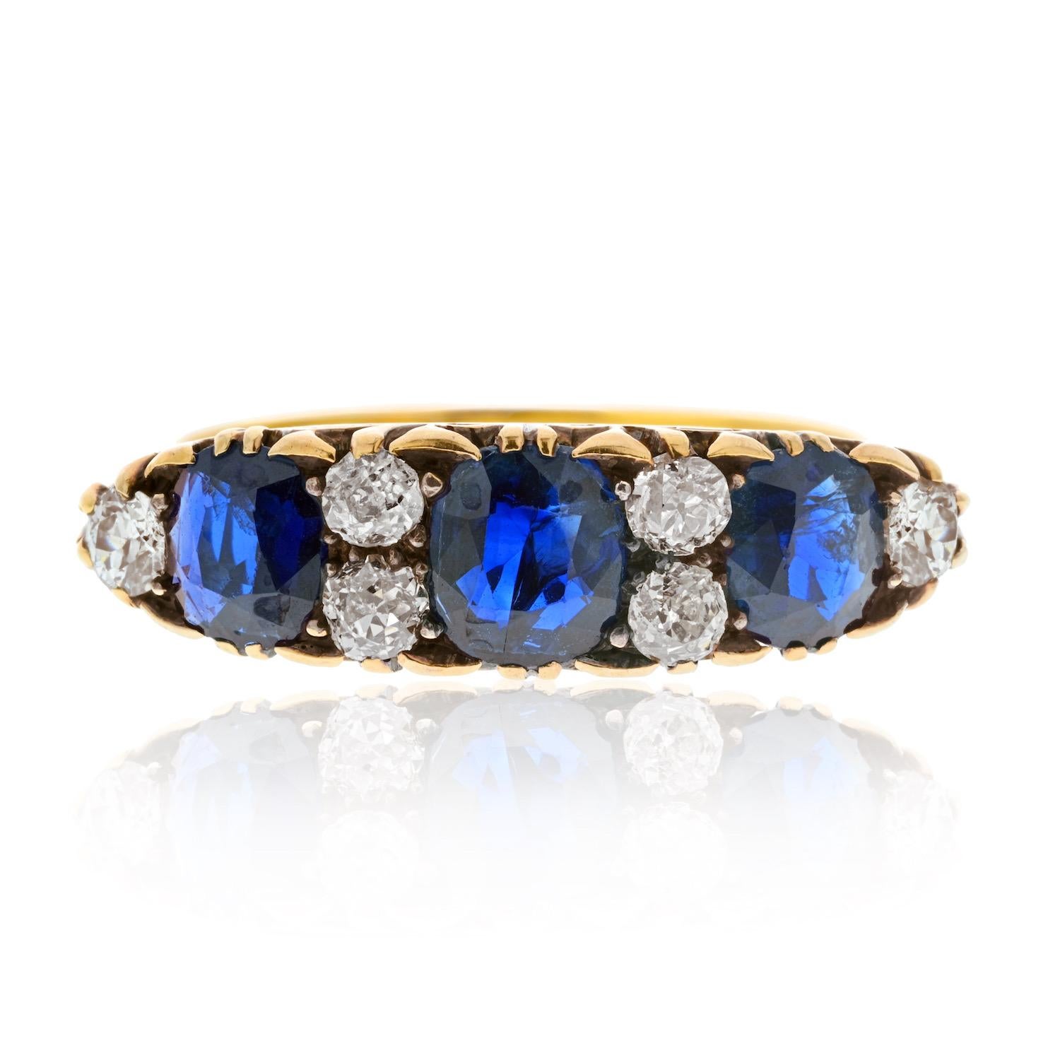 Victorian 18K Yellow Gold 3 Stone Sapphire 0.75cttw and Diamond Ring—a timeless piece that exudes elegance and charm. Crafted as a one-line band, this exquisite ring features a captivating combination of royal blue cushion-cut sapphires and old cut