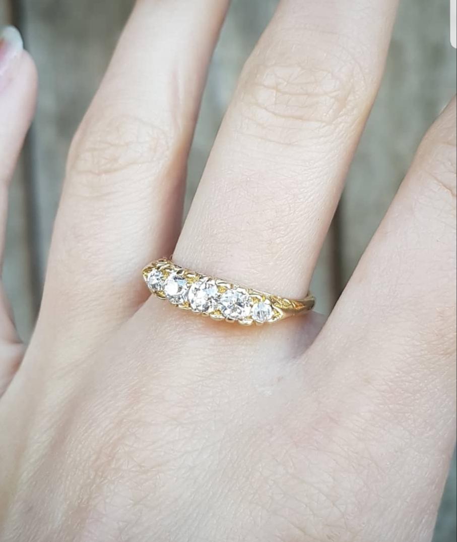 A fabulous late Victorian gold and diamond ring in excellent condition.

The ring is set with five large round graduated diamonds of virtually no color and excellent clarity set in a fine foliate gallery. The band is solid yellow gold and stamped