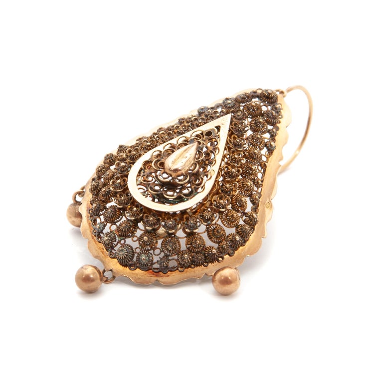 Pair of almond-shaped dangle earrings made of 14 karat gold. These earrings are rich decorated with very fine filigree and cannetille work, which are skillfully handcrafted. The finely detailed earrings have a scalloped border and a drop-shaped flat