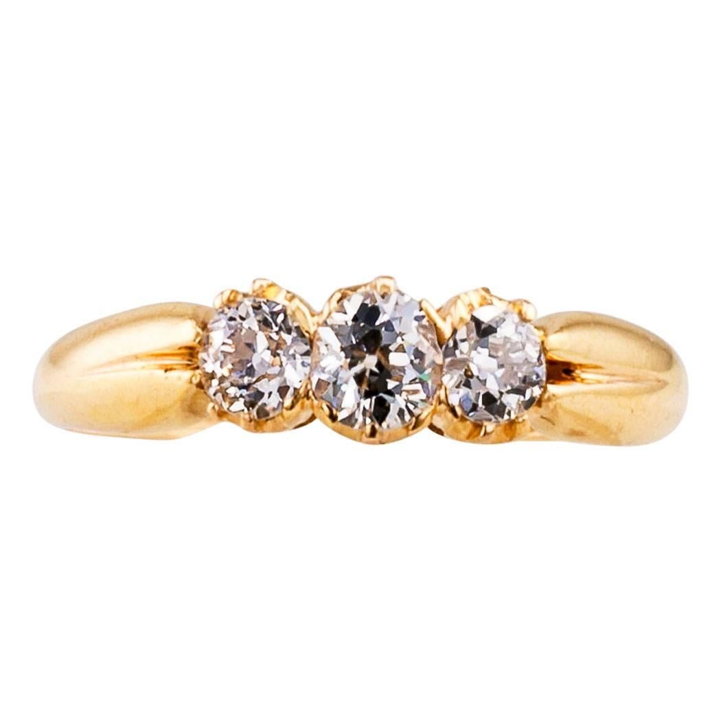 Victorian 1900s three stone diamond and gold ring. The classic design features three old mine-cut diamonds totaling approximately 0.50 carat, approximately H - I color and I1 clarity, mounted in 18-karat yellow gold. This is the quintessential