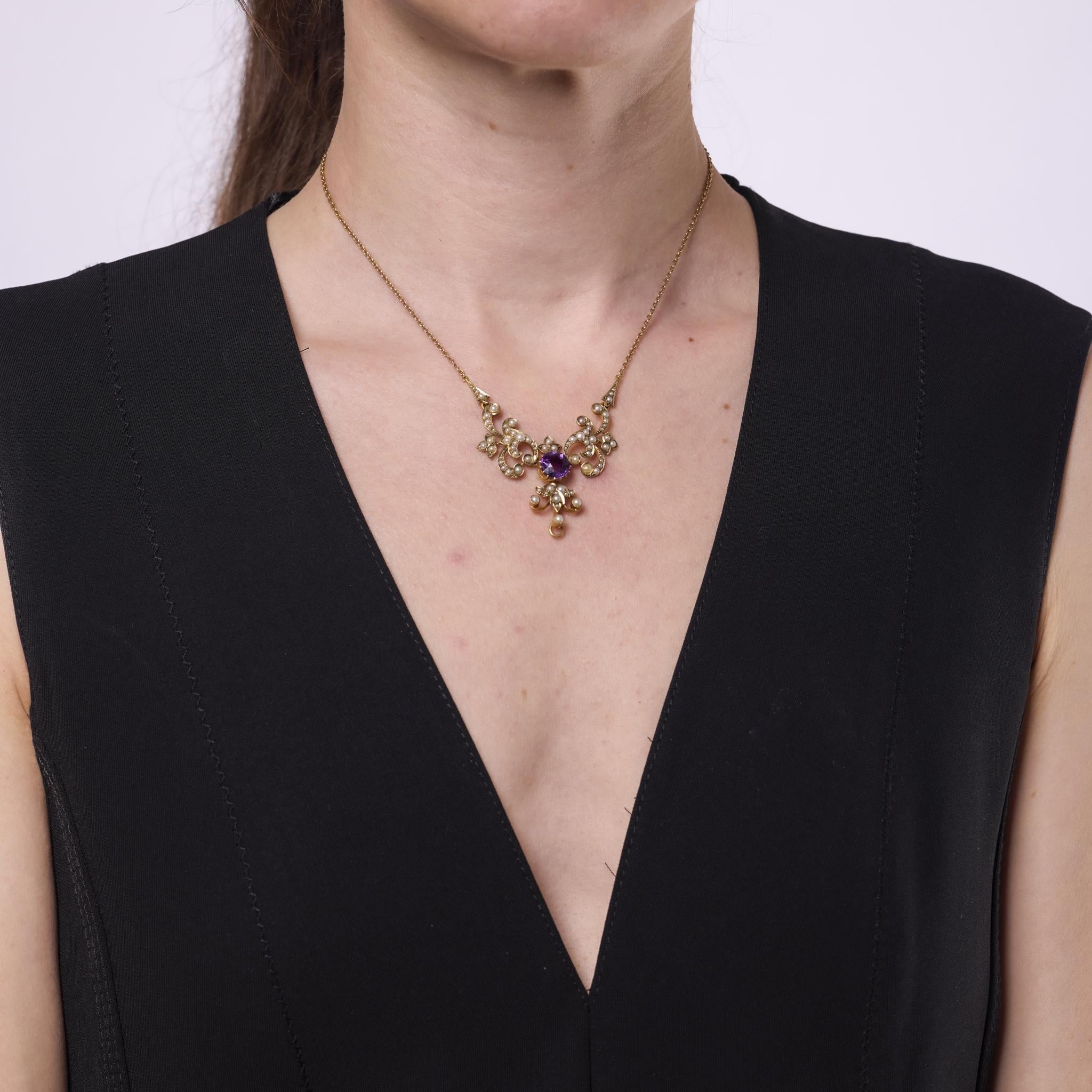 Ce collier victorien des années 1870 présente en son centre une améthyste ronde de 1,95 carat, entourée de soixante et onze perles de rocaille allant de 0,70 mm à 2,95 mm. Réalisée en or jaune 14k et poinçonnée d'une marque de pureté, cette pièce