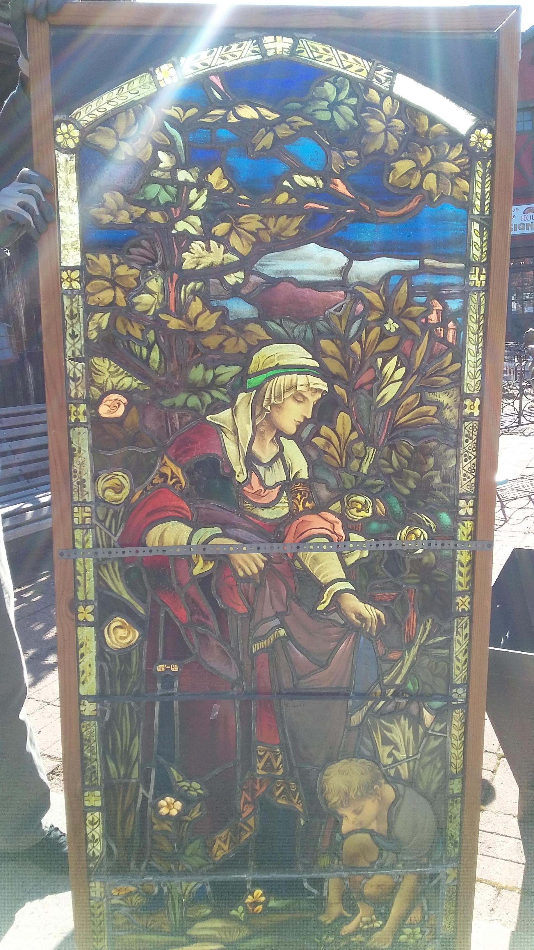 Very detailed 19th century stained-glass window. Absolute stunning and vibrant colors. All original and this window has hand painted details throughout. Beautiful woman (hand painted face) shown overlooking a kneeling child (also hand painted). This