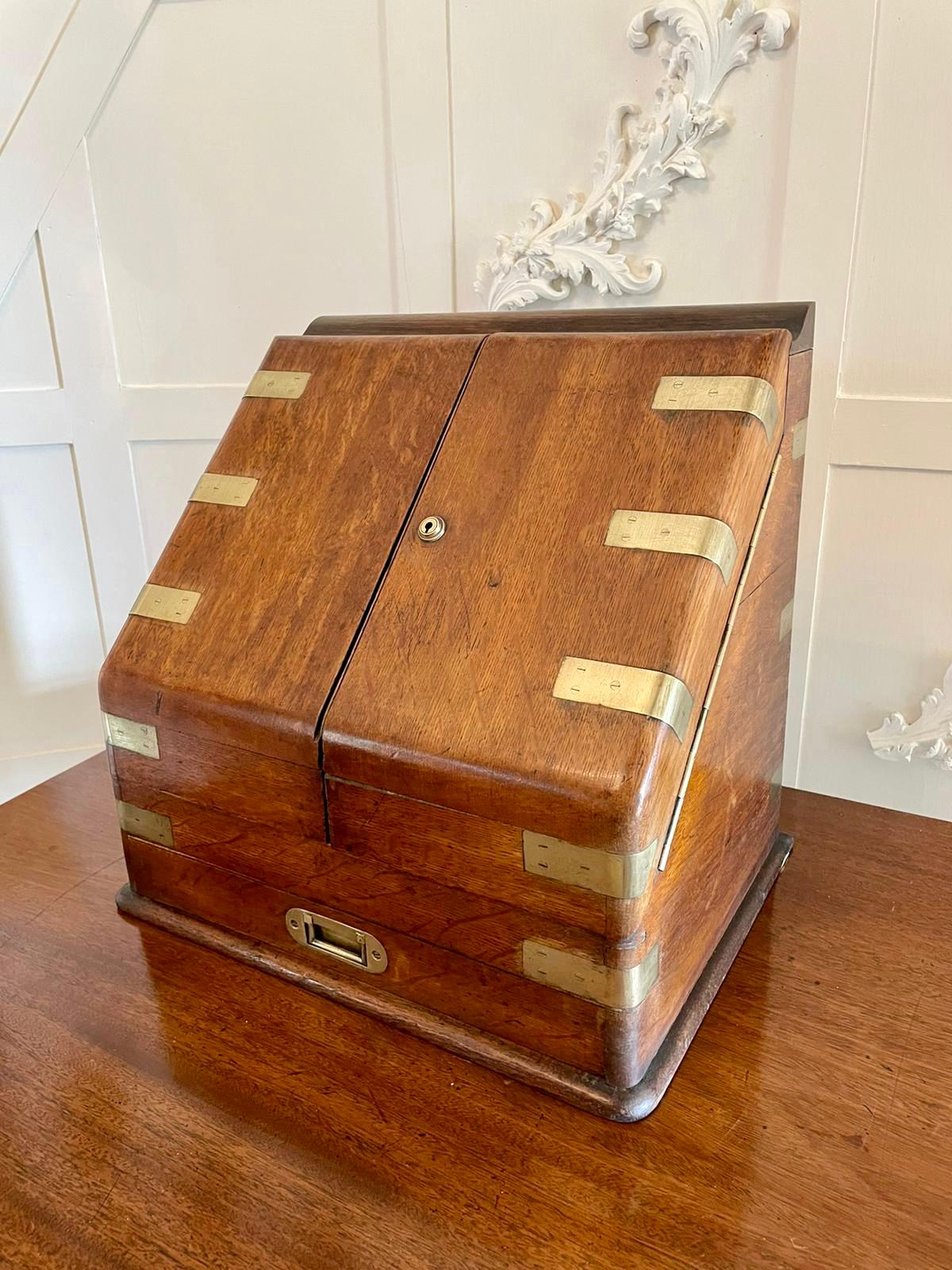 Victorian 19th century antique figured oak military stationery box having two figured oak doors with military brass bands opening to reveal a lovely fully fitted interior comprising a date, day and month calendar, shaped letter rack, pen tray,