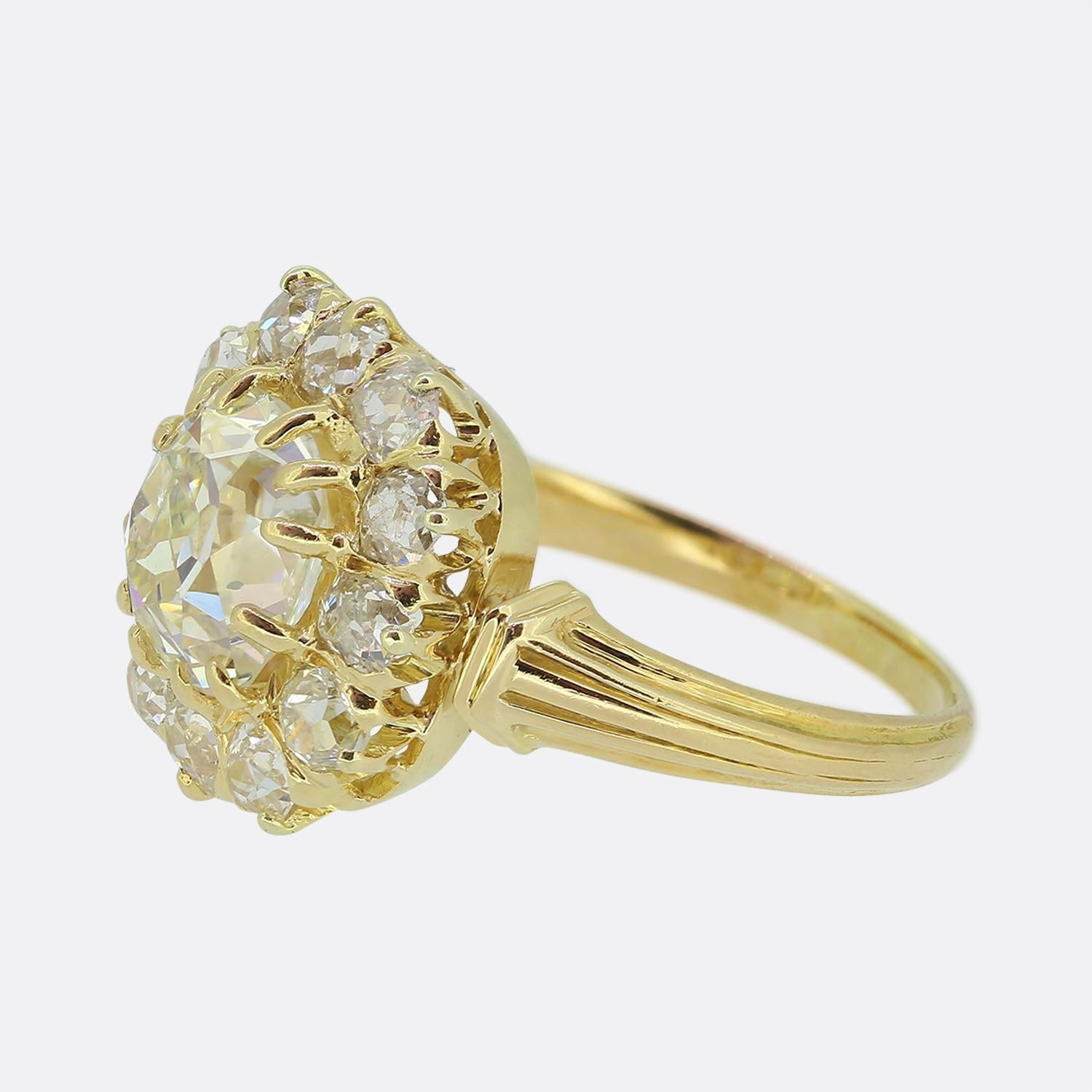 Here we have a scintillating diamond cluster ring taken from the Victorian era. This antique piece has been crafted from a rich 18ct yellow gold and features an impressive 2.00ct old cushion cut diamond at the centre of the face. This chunky