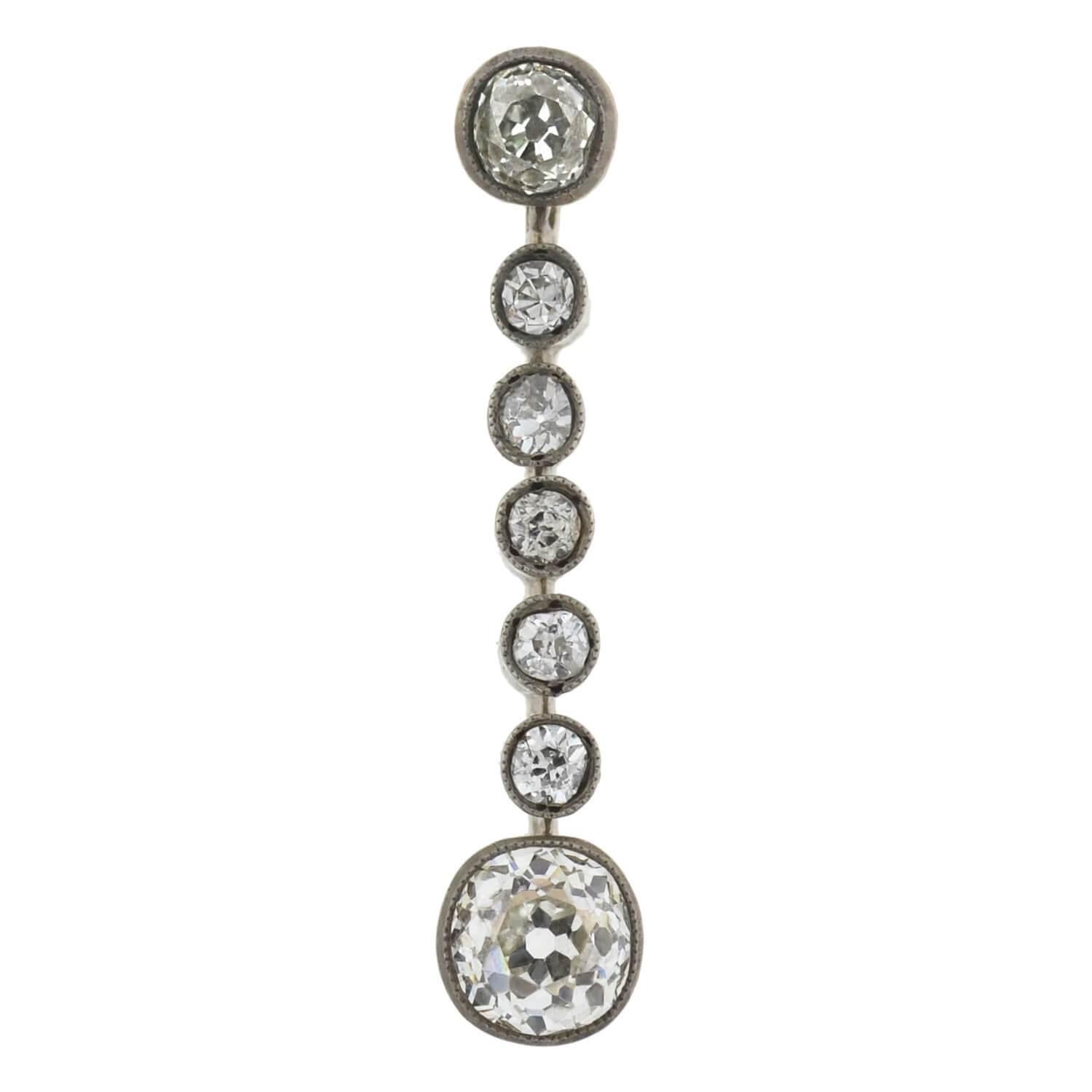 An exquisite pair of diamond drop earrings from the Victorian (ca1880) era! Crafted in 14kt yellow gold topped with sterling silver, each stunning earring adorns a sparkling row of old Mine Cut diamonds. Resting at the base is the largest diamond,