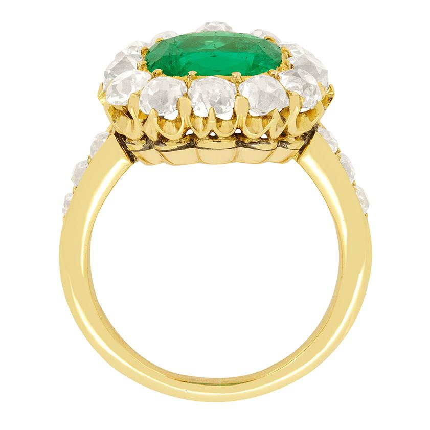 A show stopping 2.00 carat Emerald, takes pride of place in this Victorian cluster ring. The cushion cut stone is fully natural and of Columbian origin, lending to it’s vivid colouring. Enveloping the emerald, a total of 1.80 carat of old cut