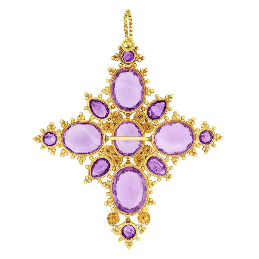 This eye catching pendant dates back to the Victorian period. The large cross motif is adorned by 20.80 carat of beautiful purple amethysts.  The centre oval stone weighs 2.80 carat with four larger 3.50 carat ovals sat at each of the cardinal