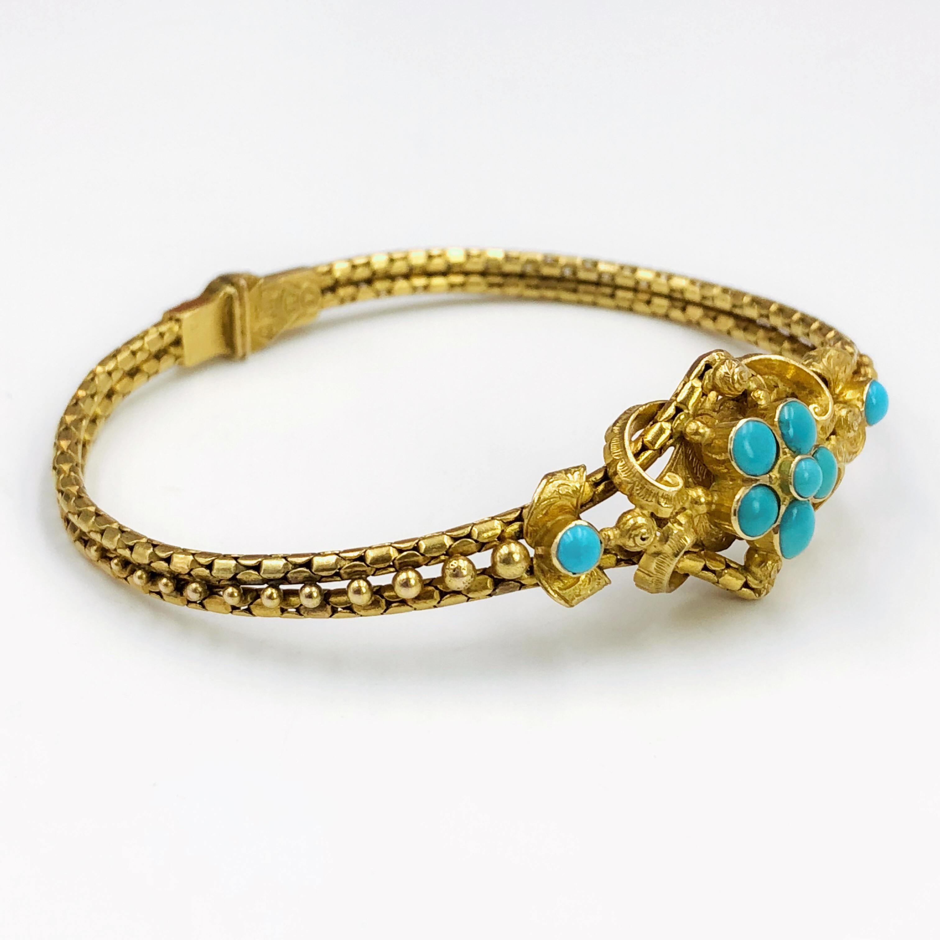 A Victorian turquoise set bracelet, circa 1840s, 21ct yellow gold, the lozenge-shaped central panel with raised scrolls and engraved detail supporting a flowerhead of cabochon turquoise stones, with glazed locket panel verso, to a two row snake-link