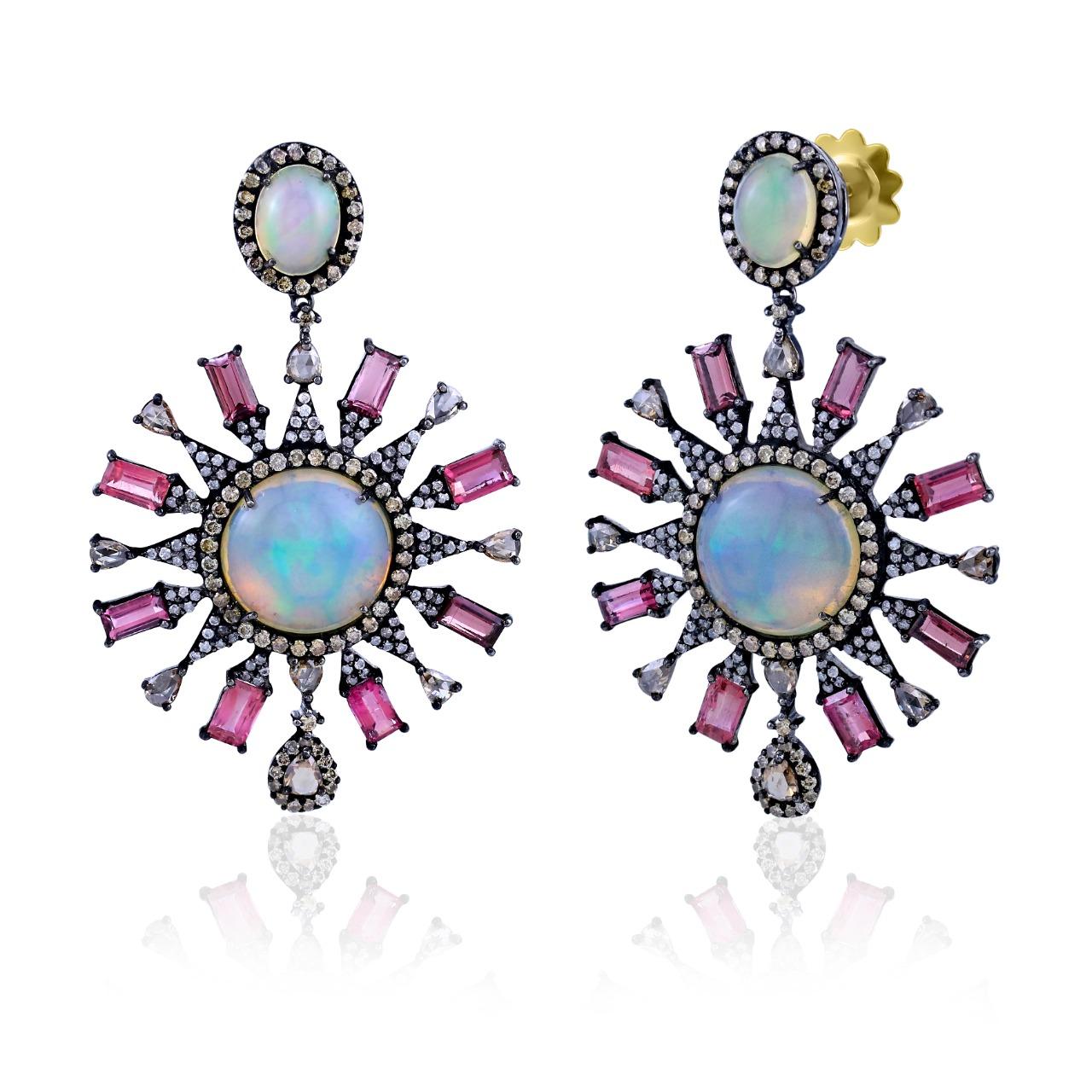 This Gemistry, majestically decorated dangle earrings are created on an 18K/925 Black Rhodium Sterling Silver body. The Victorian era jewelries are encrusted with mix diamonds, weighing 3.8 Cts. Pink mix cut Tourmaline stone, mix and cushion cab