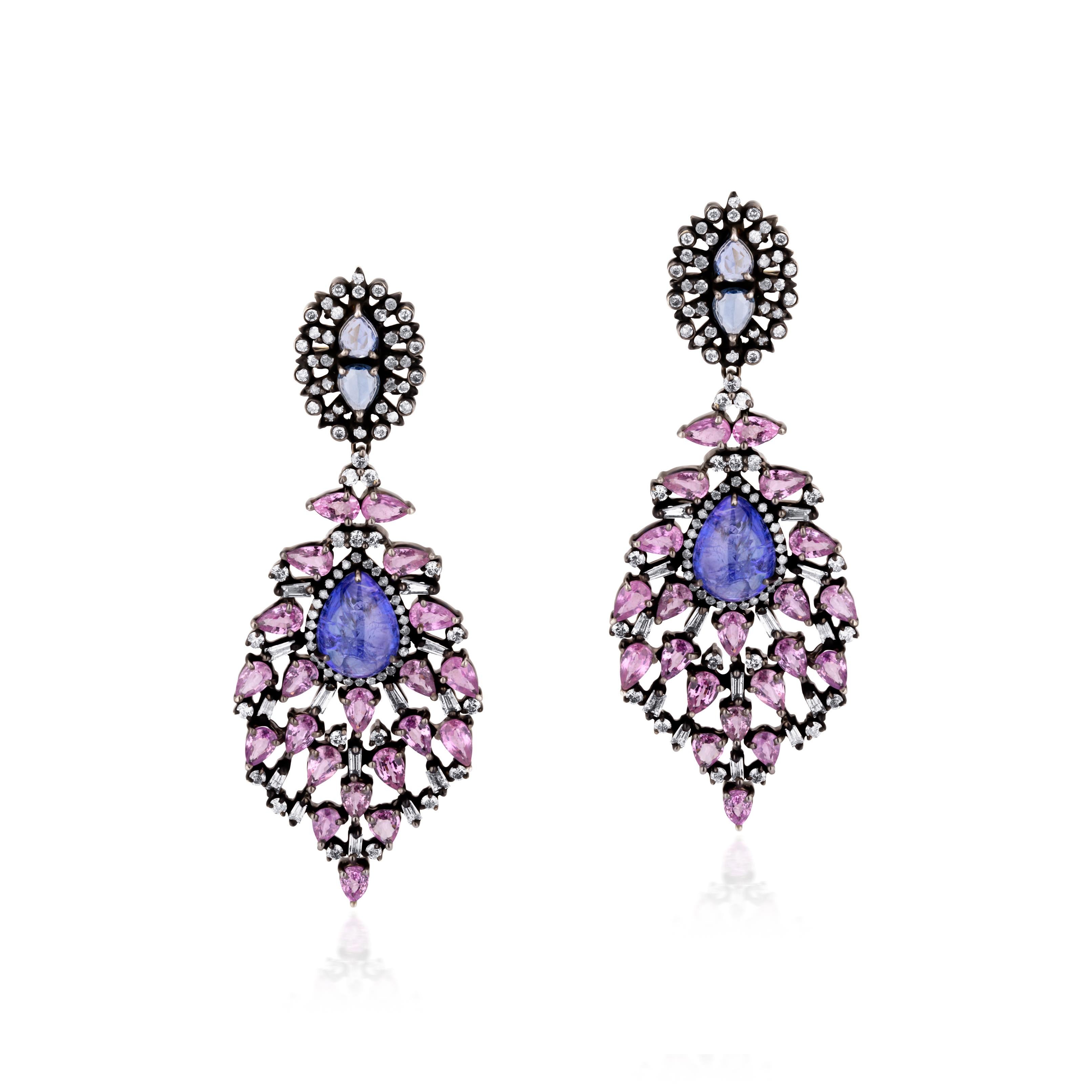 This magnificent Victorian earring is a pear to behold. The drop of the earring has a pear shaped tanzanite held in a pear frame dotted with round diamonds. The drop is further accentuated by pink sapphires linked by baguette diamonds. The surmount