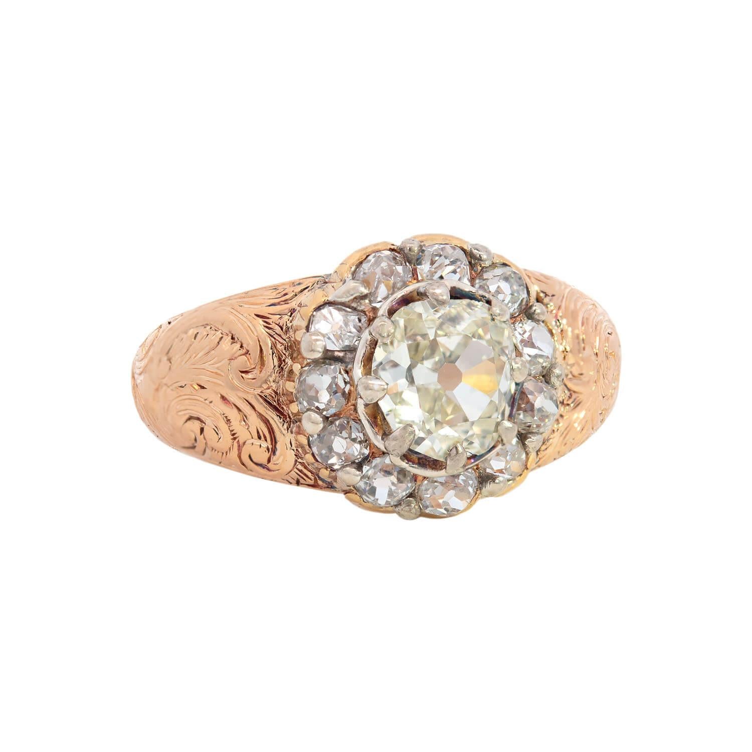 A gorgeous diamond cluster ring from the Victorian (ca1850s) era! This exquisite ring is made of vibrant 22kt yellow gold topped in sterling silver. A sparkling 1.35ct old mine cut diamond of K/L color and VS1-VS2 clarity is surrounded by eleven