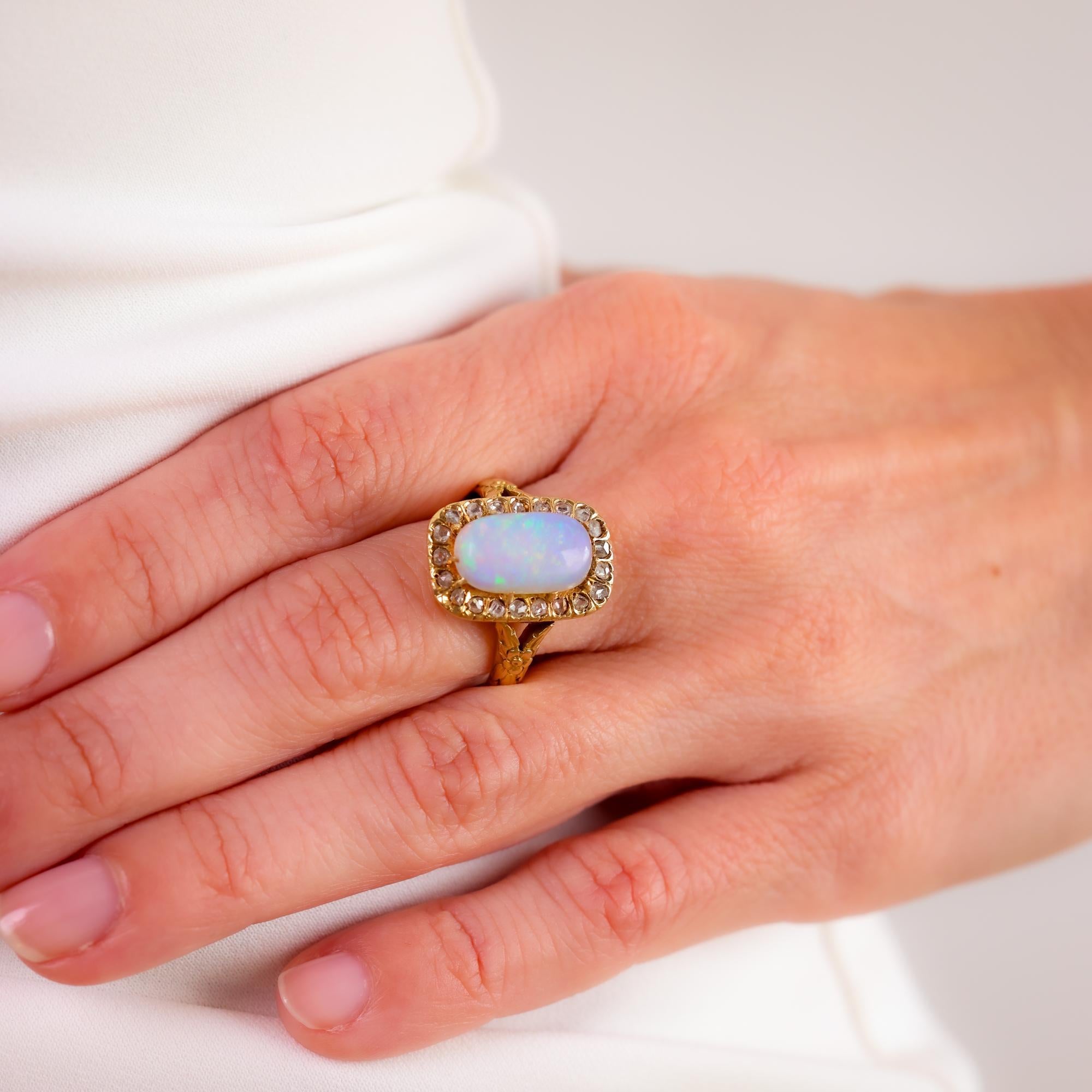 This Victorian 18k yellow gold ring showcases a mesmerizing 2.30 carat opal, surrounded by 21 sparkling rose cut diamonds, exuding antique charm and elegance.

Center stone: Cabochon cut opal
Weight: Approximately 2.30 carat
Accent stone: 21 rose