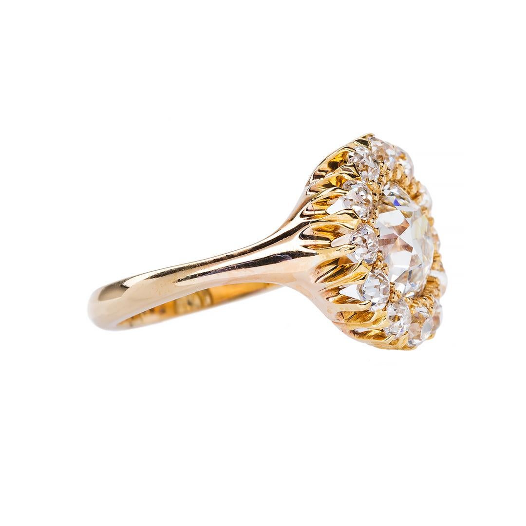 This ring is an incredible example of Victorian era (circa 1890) craftsmanship and design. The 14k yellow gold vintage ring centers a 2.31ct EGL certified Old European Cut diamond graded J color and VS1 clarity. The bold center stone is surrounded
