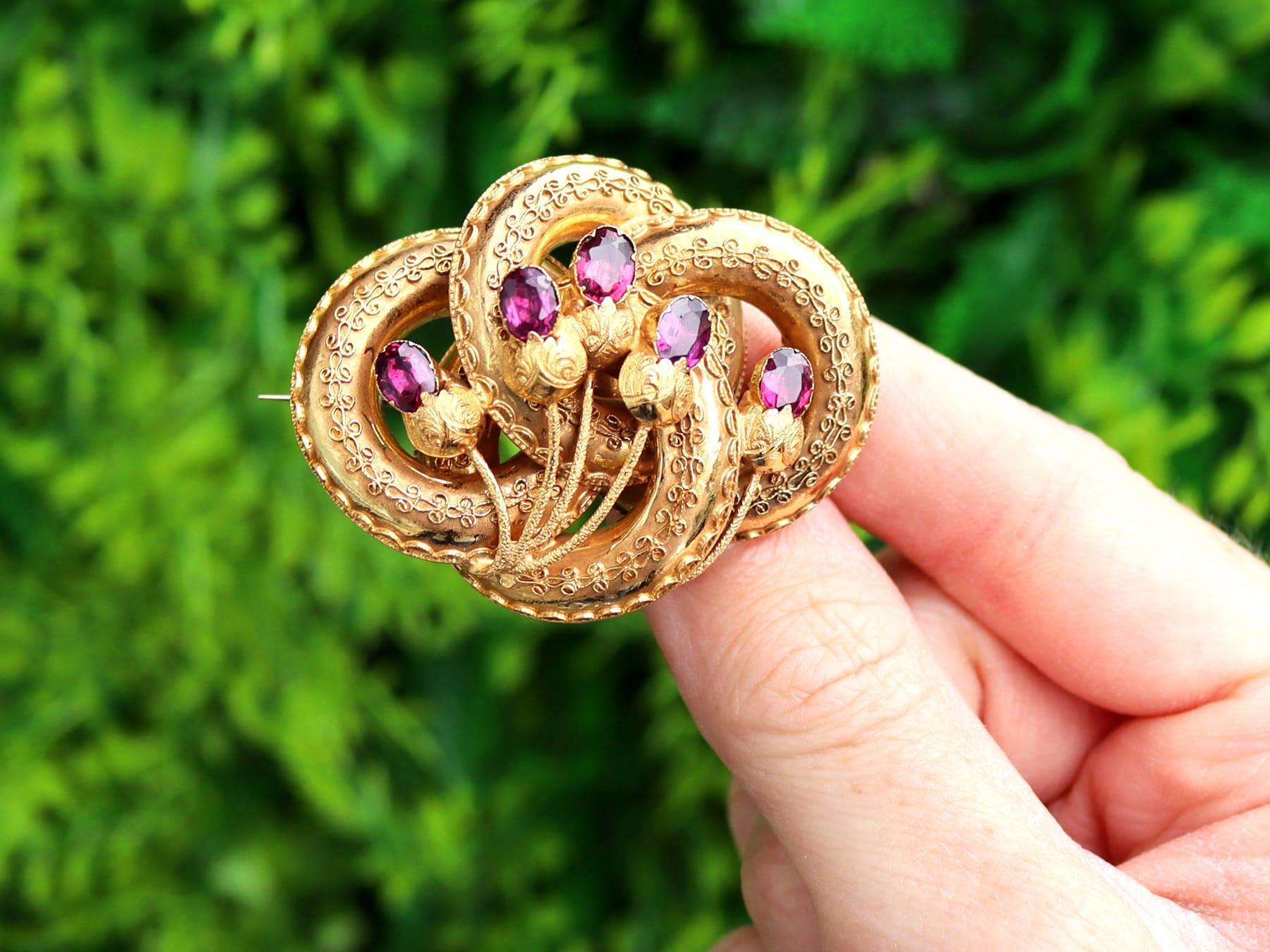 This excellent, fine and impressive antique brooch has been crafted in 21ct yellow gold.

The brooch has an interlacing knotted form, accented with applied scrolling filigree style decoration, all in an iconic Victorian design.

The brooch is
