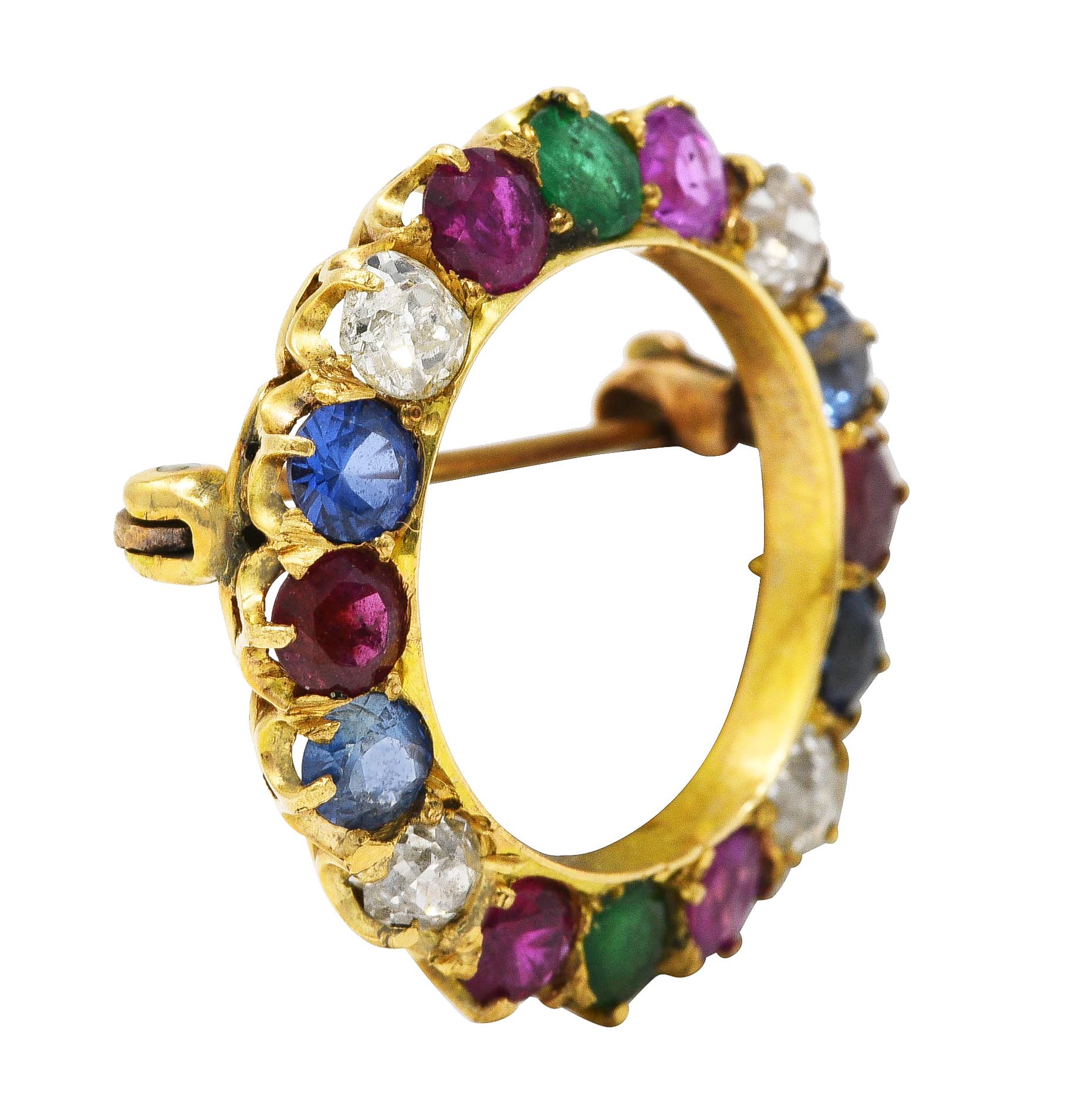 Circular brooch is set throughout by round cut gemstones - blue sapphires, pink sapphires, rubies, emeralds, and diamonds

Old mine cut diamonds weigh in total approximately 0.55 carat - I/J color with SI1 clarity

Emeralds weigh approximately 0.18