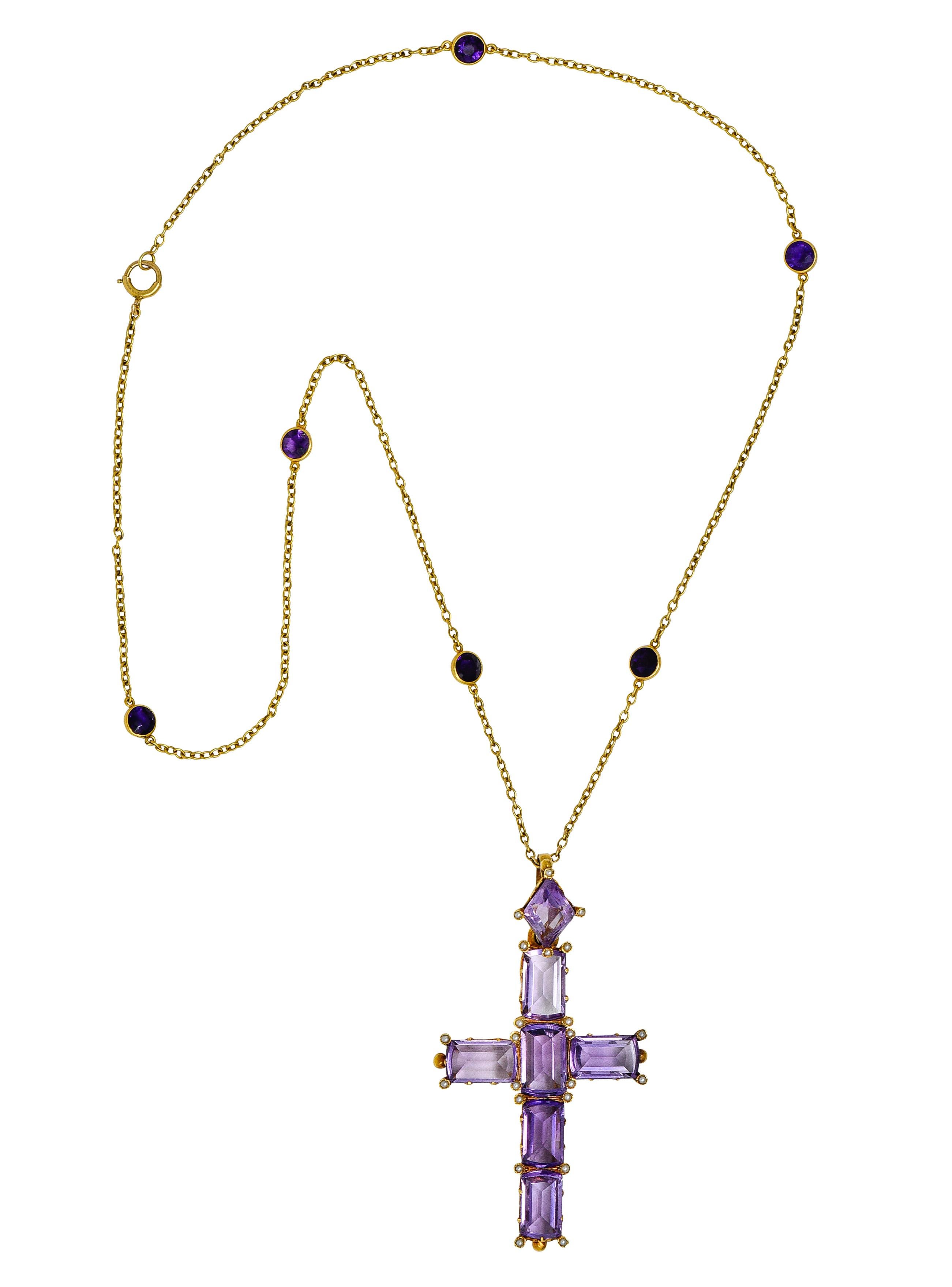 Featuring a cross pendant comprised of mixed emerald cut amethysts with a diamond shaped amethyst surmount. Transparent pinkish purple with natural inclusions with light/medium saturation. Set in mountings with stylized scrolling fleur-des-lis