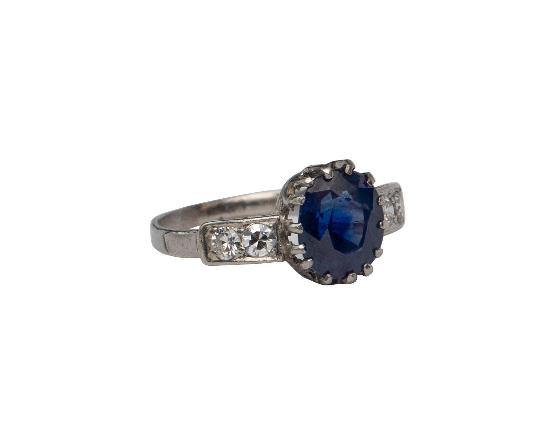 This is an gorgeous example of a late Victorian era sapphire ring! The stunning 2.66 carat deep royal blue sapphire sits proudly in a crown of fancy prongs! The ring is crafted in platinum and accents the impressive center with two simple rose cut