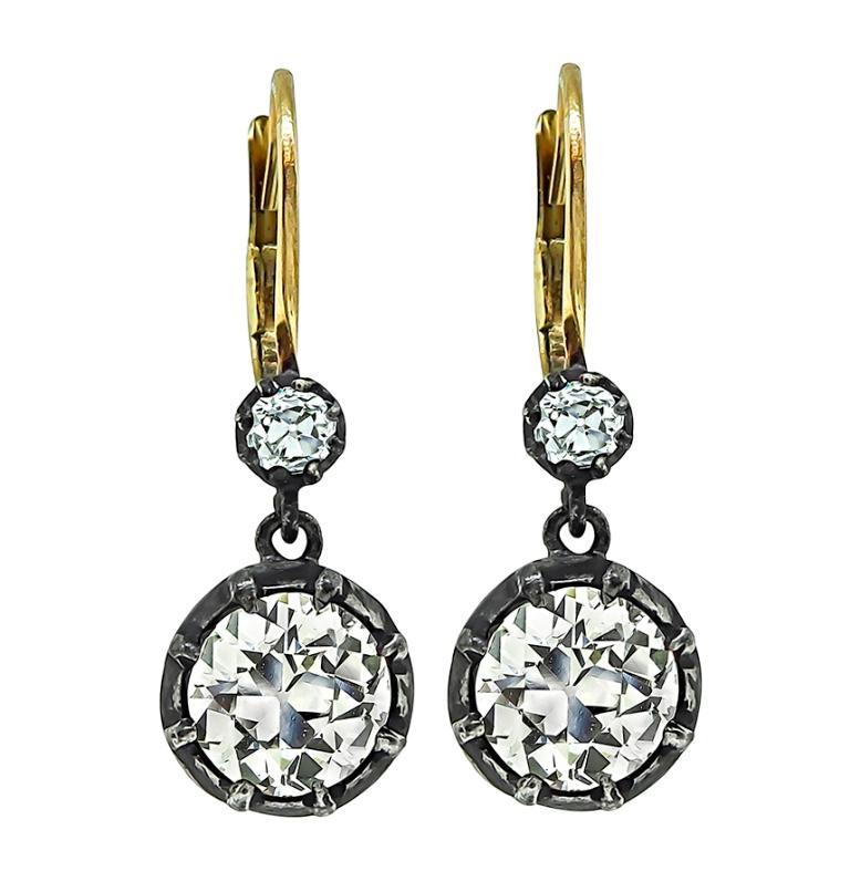 This stunning pair of silver and gold earrings from the Victorian era feature sparkling old mine cut diamonds that weigh 2.69ct. The color of these diamonds is L-M with VS1 clarity. The diamonds are accentuated by two small old mine cut diamond