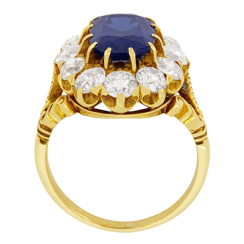 An incredible intense blue sapphire sits central in this Victorian cluster ring. The 3.00 carat sapphire is a natural and unheated stone and is surrounded by twelve old cut diamonds totalling 2.10 carat. All the diamonds match in colour at G and