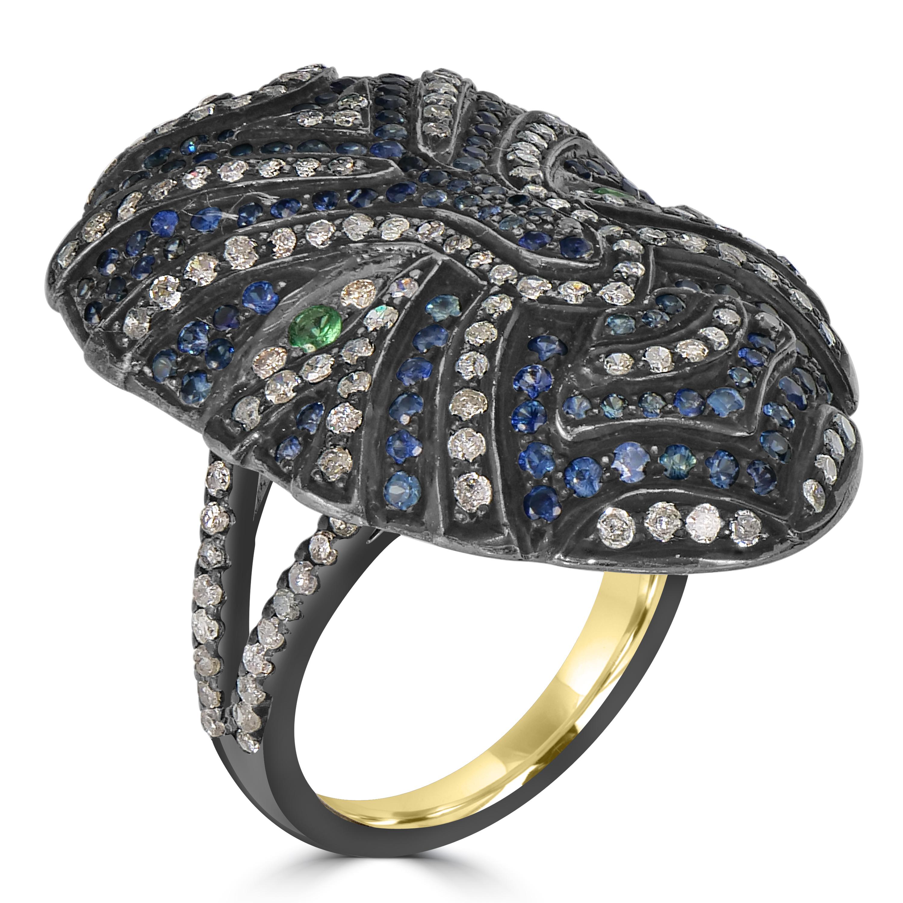 Dive into the mystique of the Victorian 3.3 Cttw. Blue Sapphire, Tsavorite, and Diamond Full Face Mask Ring — a captivating fusion of avant-garde design and opulent gemstones. Crafted in sterling silver with a black rhodium top, the ring head takes