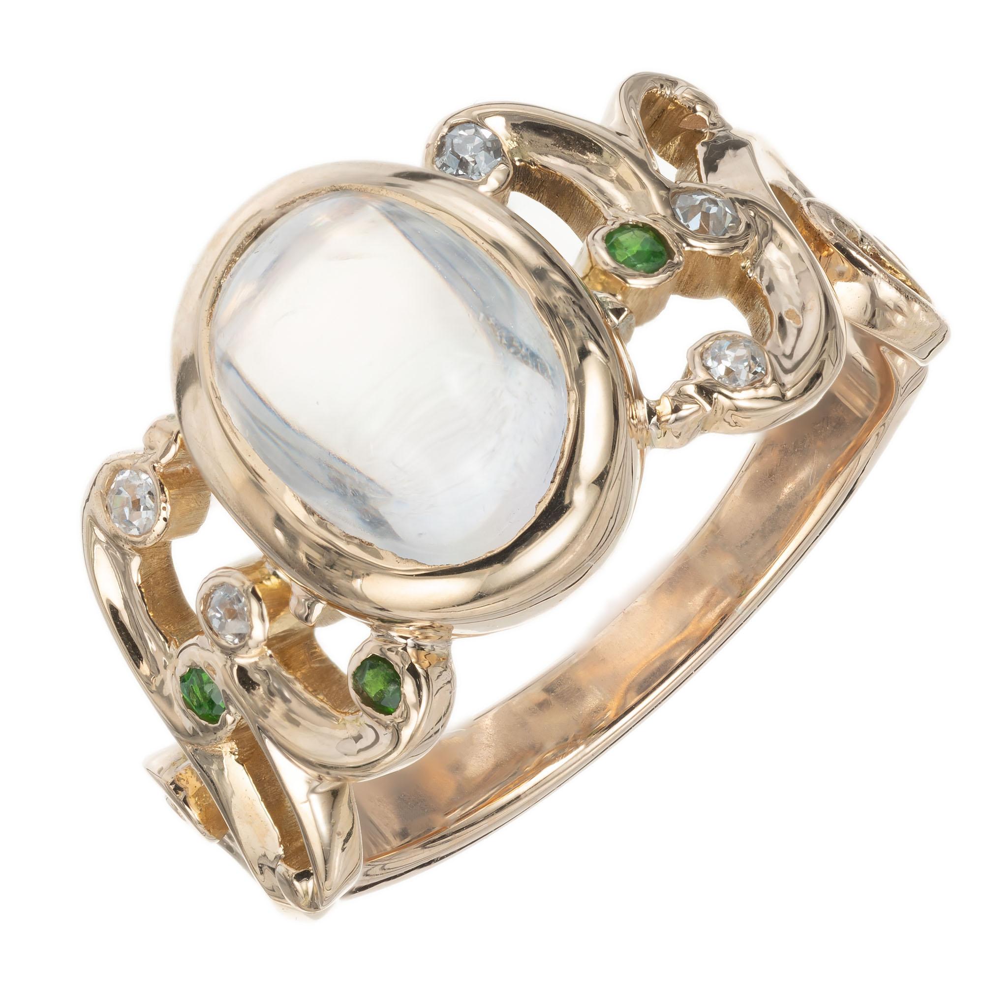 1900's Victorian moonstone, diamond and garnet ring. 3.30ct oval center stone, accented with 3 green demantoid garnets and 5 old European cut diamonds in 14k yellow gold setting. 

1 oval cabochon clear with blue essence moonstone, VS approx.