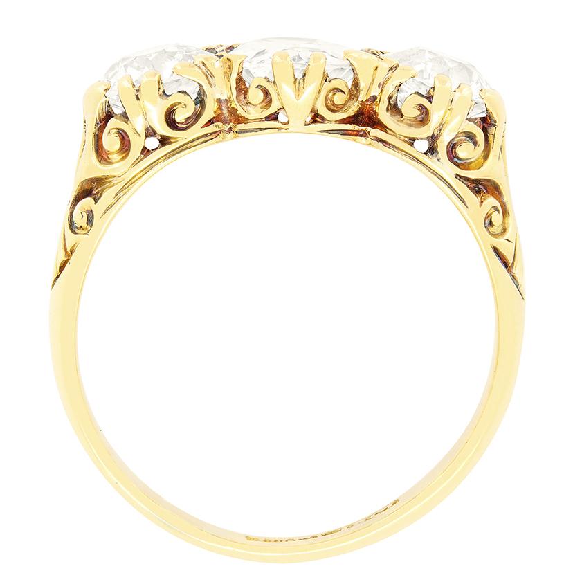 This Victorian three stone, carved head ring is a masterpiece of timeless elegance.  The central of the diamonds is the largest, a sparkling 1.50 carat old oval cut diamond. Flanking it on either side are two 1.00.carat old cut diamonds, creating a