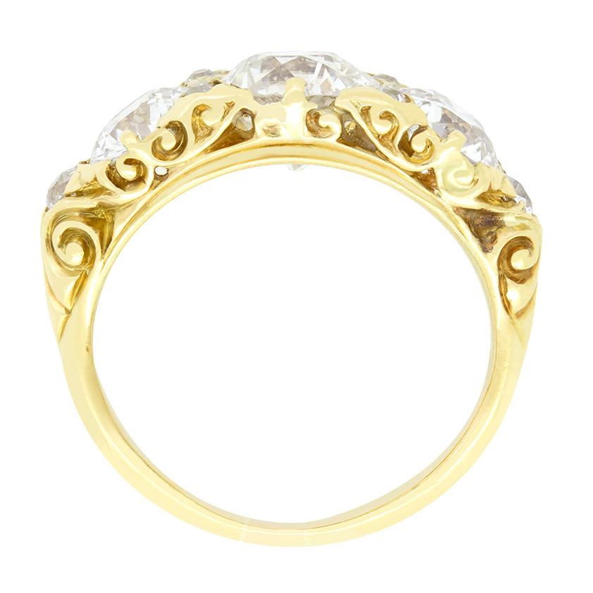 Cette superbe bague trilogie à tige sculptée date de l'époque victorienne. Au centre, trois étincelants diamants de taille ancienne sont sertis avec quatre autres diamants de taille rose, ce qui leur confère un éclat supplémentaire. La pièce