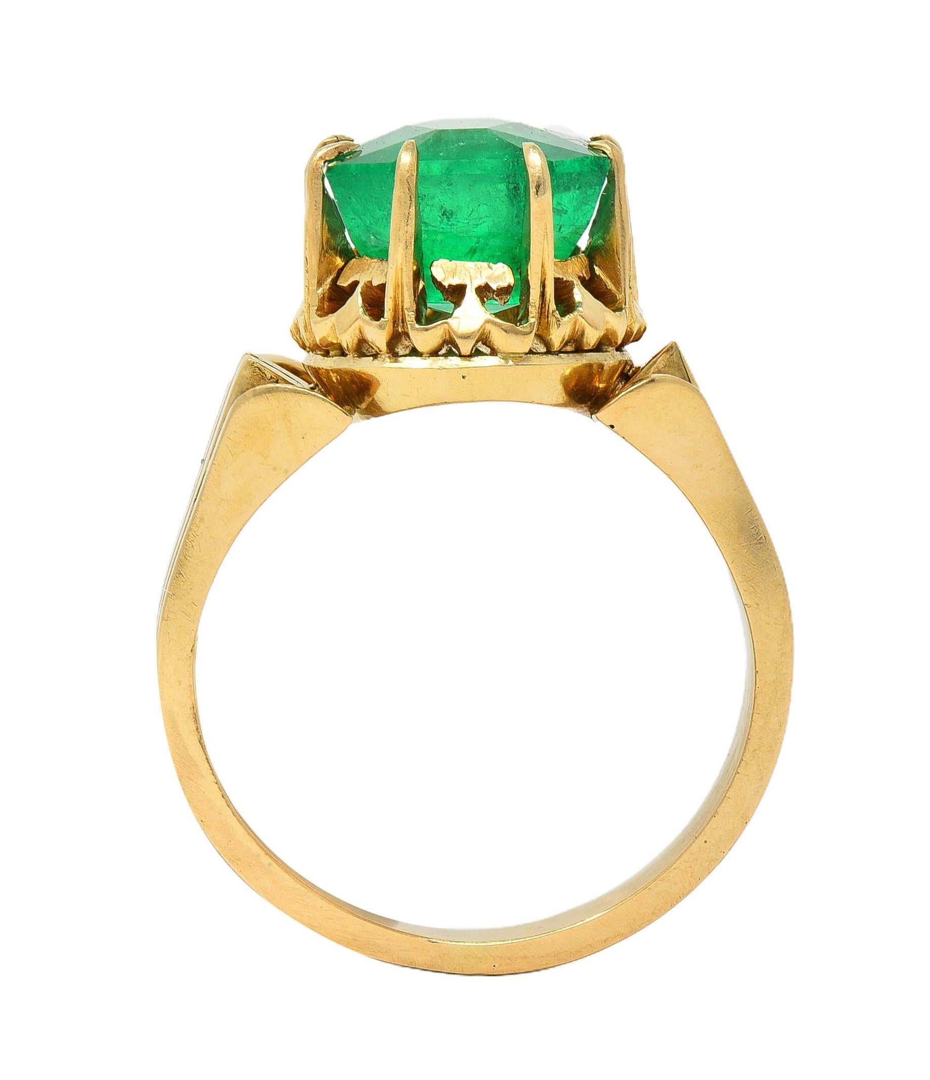 Centering an emerald cut emerald weighing approximately 3.60 carats total 
Natural Colombian in origin with minor clarity enhancement (F1) 
Transparent, vibrant medium green in color 
Set with talon prongs in a pierced crown-style mounting 
Flanked