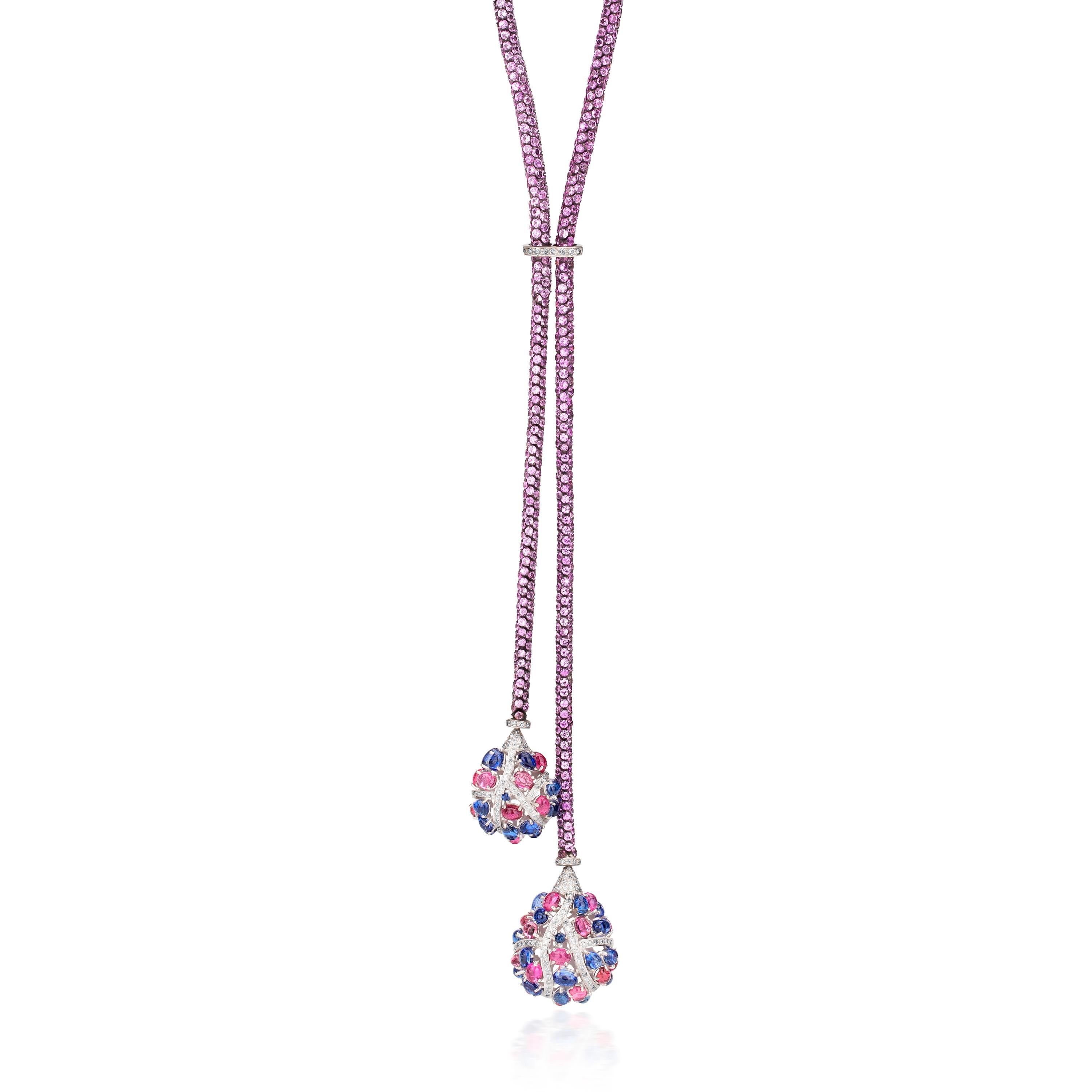 This beautiful Victorian style lariat necklace, crafted in 18K gold and 925 sterling silver, has a pair of blue oval kyanite and pink oval tourmaline laden drops. These oval stones are brought together with shimmering diamond bands. The drops swing