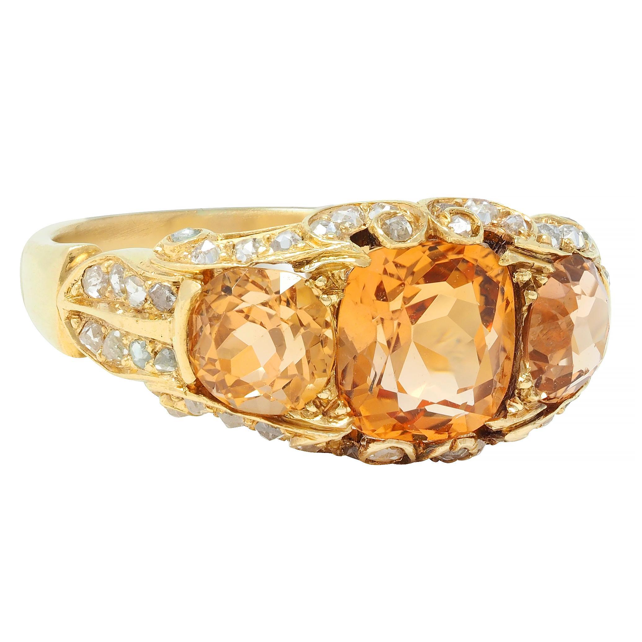Centering a prong set cushion cut topaz weighing approximately 1.96 carats total 
Flanked by round mixed-cut topaz weighing approximately 1.60 carats total 
Transparent medium pinkish-orange to orange in color 
Prong set east to west with a pierced