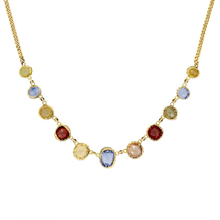 A collection of beautiful coloured gemstones adorn this fabulous Victorian necklace. The centre blue sapphire is 2.00 carat, to either side are 1.75 carat champagne coloured zircons. Two red garnets follow, weighing 2.30 carat each, while a set of 