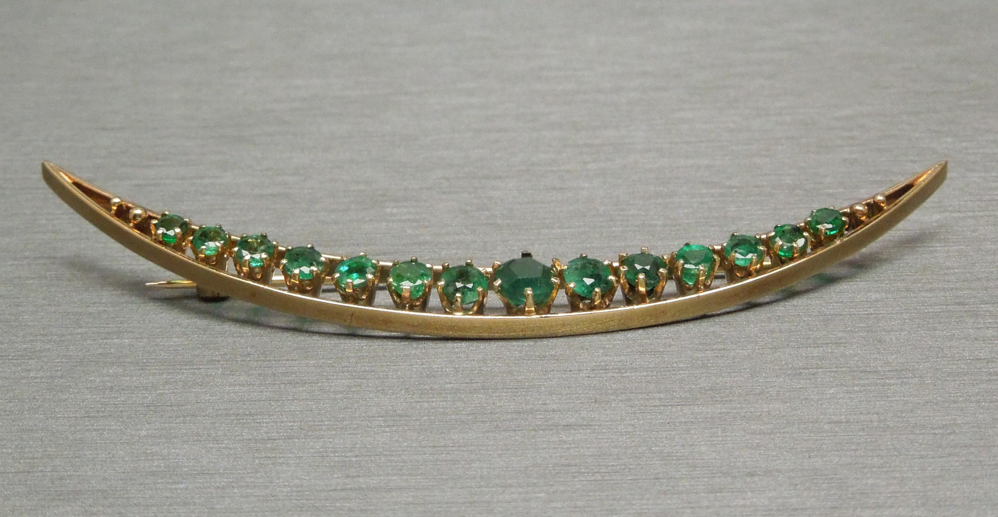 This Emerald crescent pin from our New Orleans Estate Collection resembles the pieces crafted by the Goldsmiths in New Orleans, LA in the Victorian era. The crescent design resembling the Crescent City of New Orleans. In 14KT Yellow Gold, containing