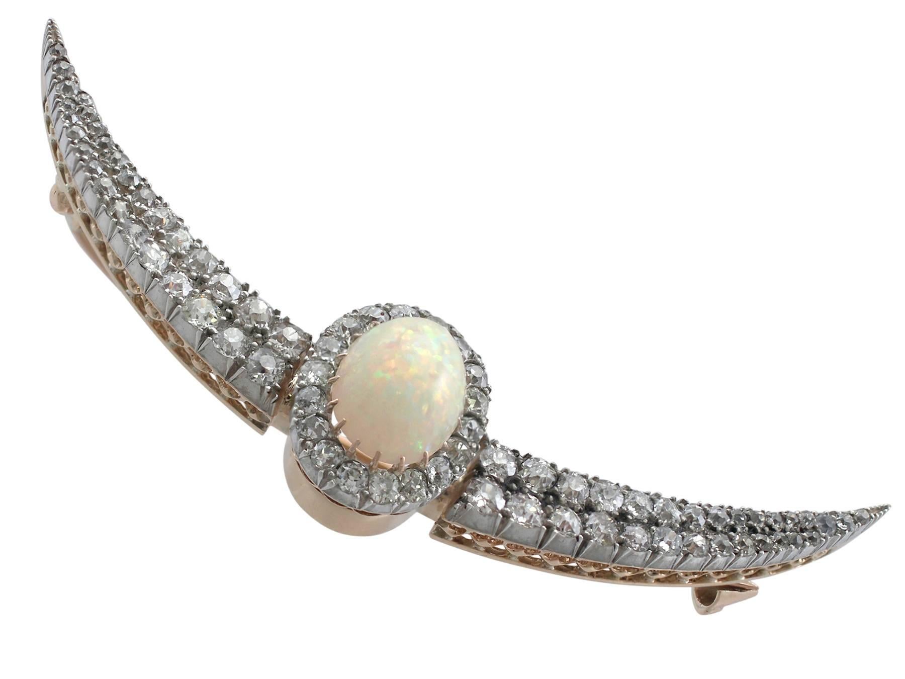 A stunning Victorian 4.75 carat opal and 4.45 carat diamond, 9 karat yellow gold and silver set crescent brooch; part of our diverse antique jewelry collections

This stunning, large, fine and impressive cabochon cut opal and diamond brooch has been