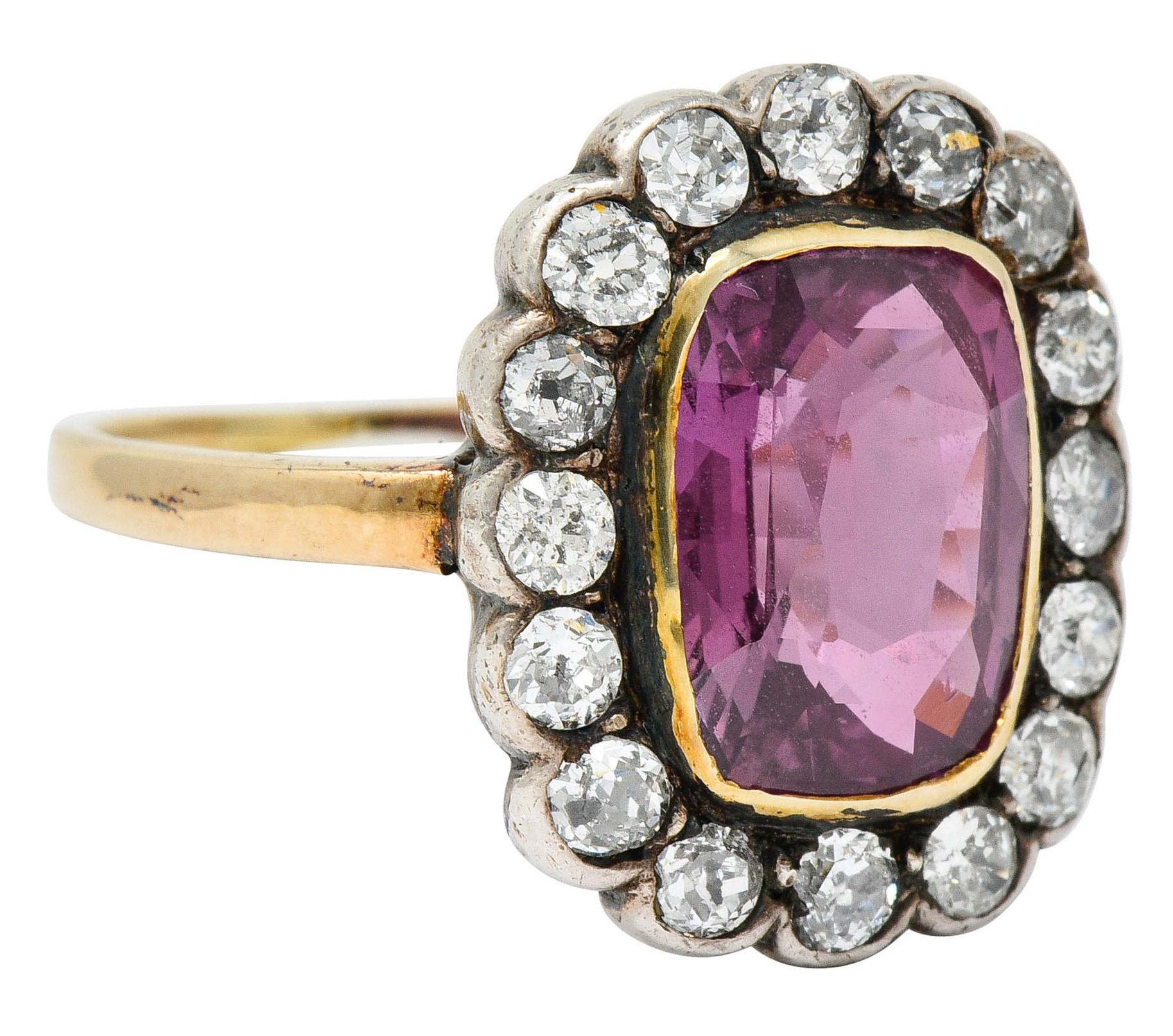 Cluster ring centers a rectangular cushion cut pink sapphire weighing 3.95 carats

Transparent with a light brownish-pink color and no indications of heat

Surrounded by a diamond halo of old mine and old European cut diamonds, bezel set in
