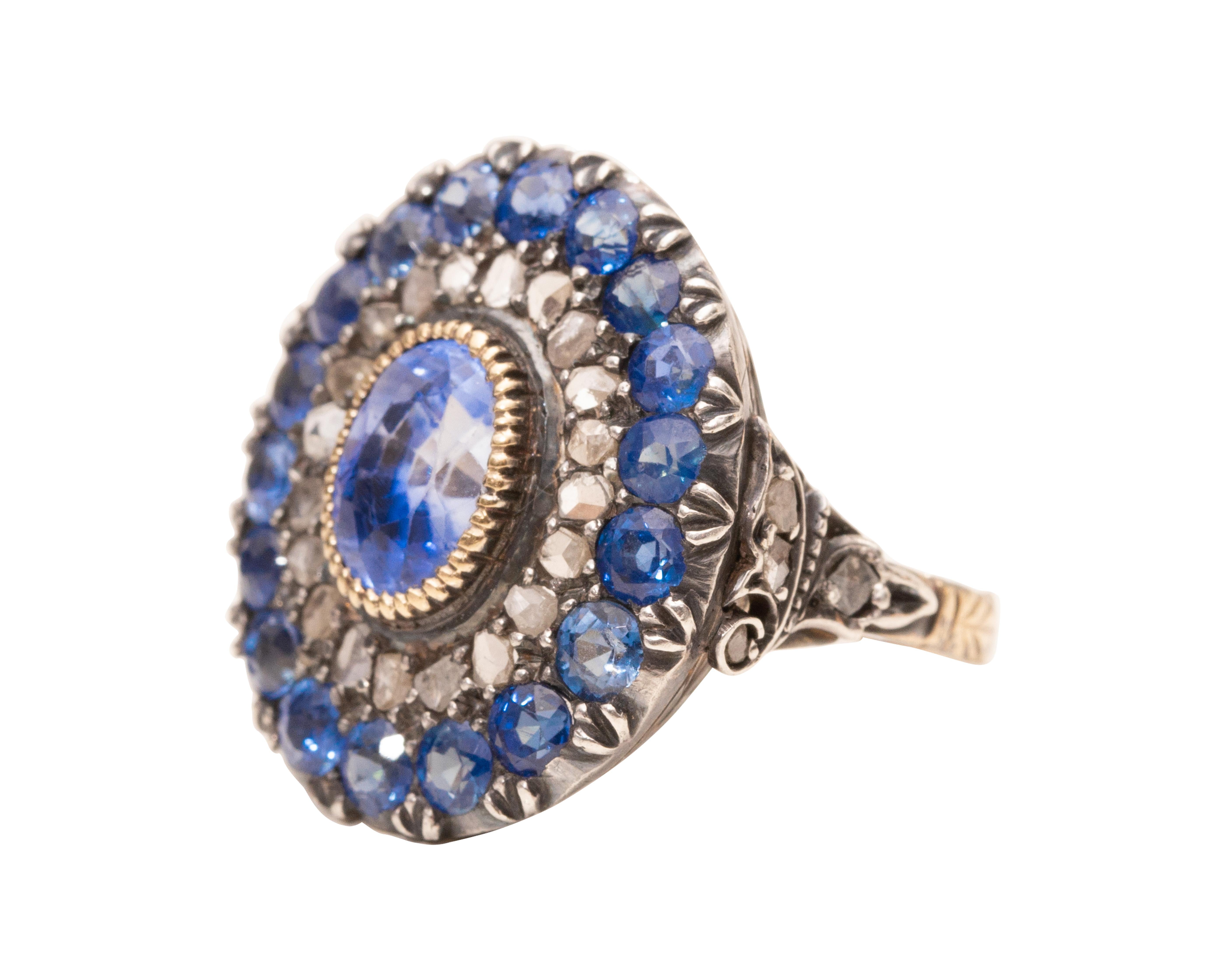 This stunning example of an early Victorian era sapphire ring is one of the best we've ever seen! The stunning 2.5 carat deep cornflower blue sapphire steals the show surrounded by a halo of  antique polki cut diamonds and even more sapphires!