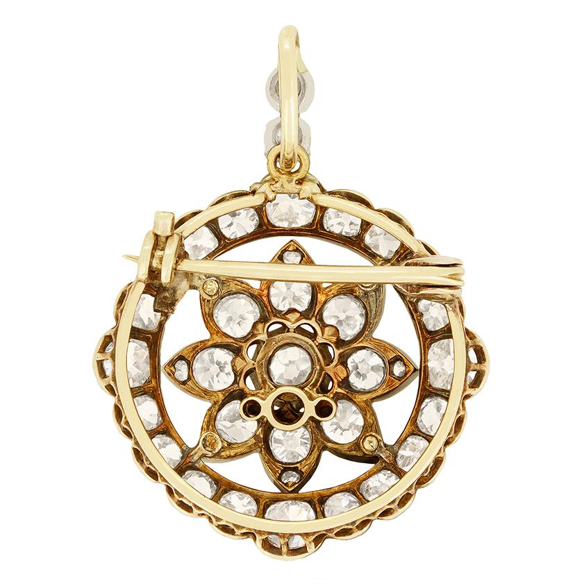 Dieses exquisite viktorianische Stück kann sowohl als Anhänger als auch als Brosche getragen werden. Das Herzstück ist ein funkelnder Diamant im Altschliff, der von einem floralen Arrangement aus weiteren Altschliffen umgeben ist und so ein