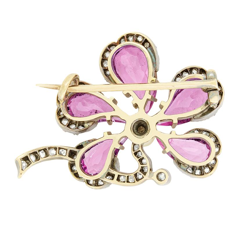Diese atemberaubende Brosche, die im viktorianischen Zeitalter handgefertigt wurde, ist ein echtes Unikat. Das florale Design dreht sich um eine Kollektion von fünf rosa Saphiren im alten Herzschliff. Der zentrale Stein ist mit 1,50 Karat der