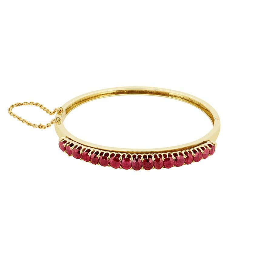 In this fabulous Victorian bangle, seventeen natural, unheated rubies are claw set into a 15ct yellow gold setting. The rubies graduate in sizes, starting off with 0.25 carats at either end and the largest ruby weighing 0.40 carat sat in the centre.