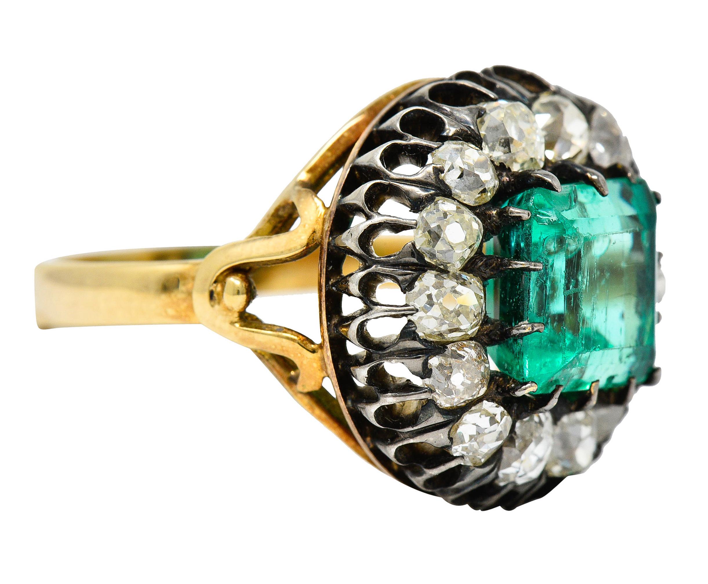 Cluster ring centers a Colombian emerald cut emerald weighing approximately 2.85 carats

Transparent with medium light bluish green color and minor clarity enhancements (F1)

Surrounded by a halo of old mine cut diamonds - set in a silver belcher
