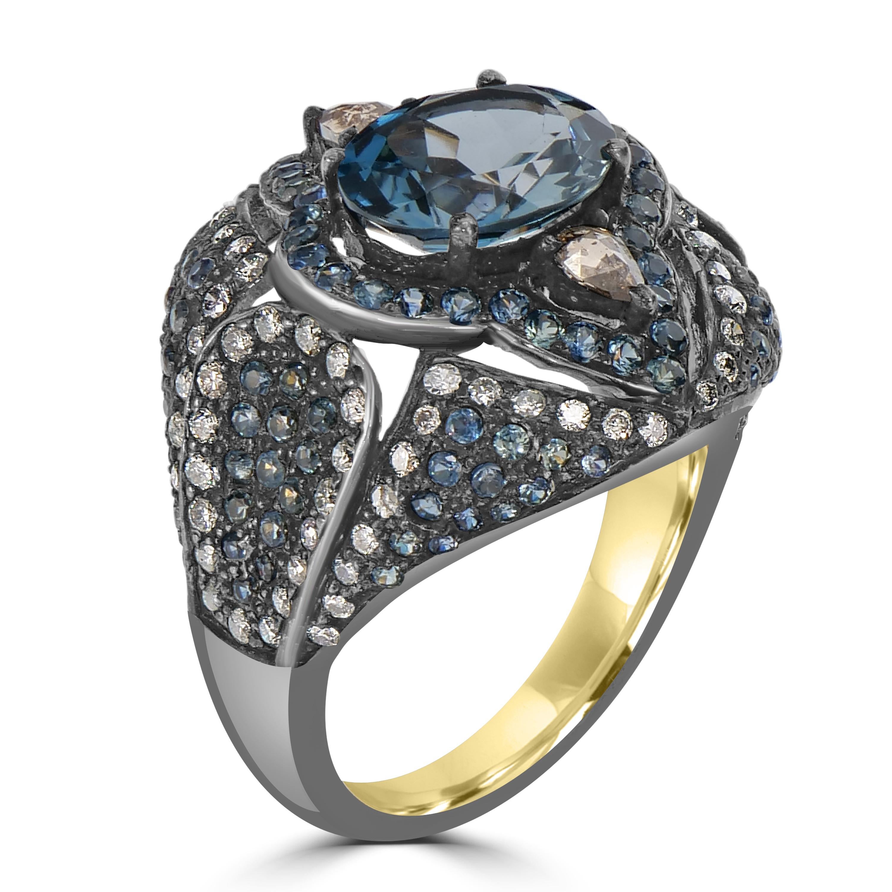 Embrace the allure of the Victorian era with the 5.3 Cttw. London Blue Topaz, Sapphire, and Diamond Open Work Dome Ring — a stunning fusion of vintage charm and contemporary sophistication. At its heart lies an oval London Blue topaz, elegantly