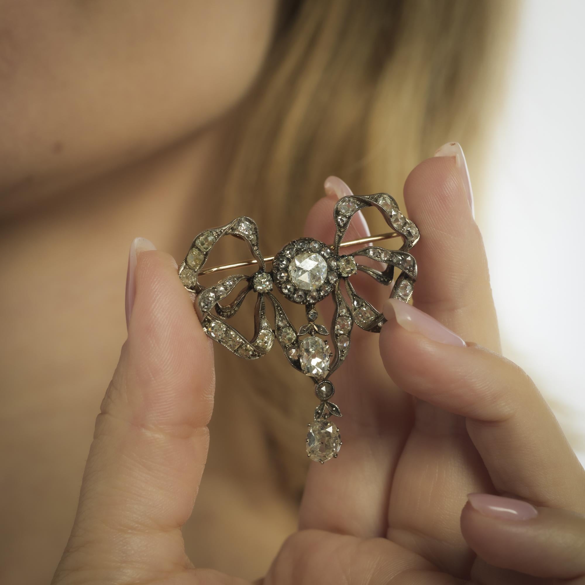 Cette broche victorienne présente 5,50 carats de diamants de taille ancienne et de diamants taillés en rose dans un gracieux motif d'inspiration florale en or rose et en argent.