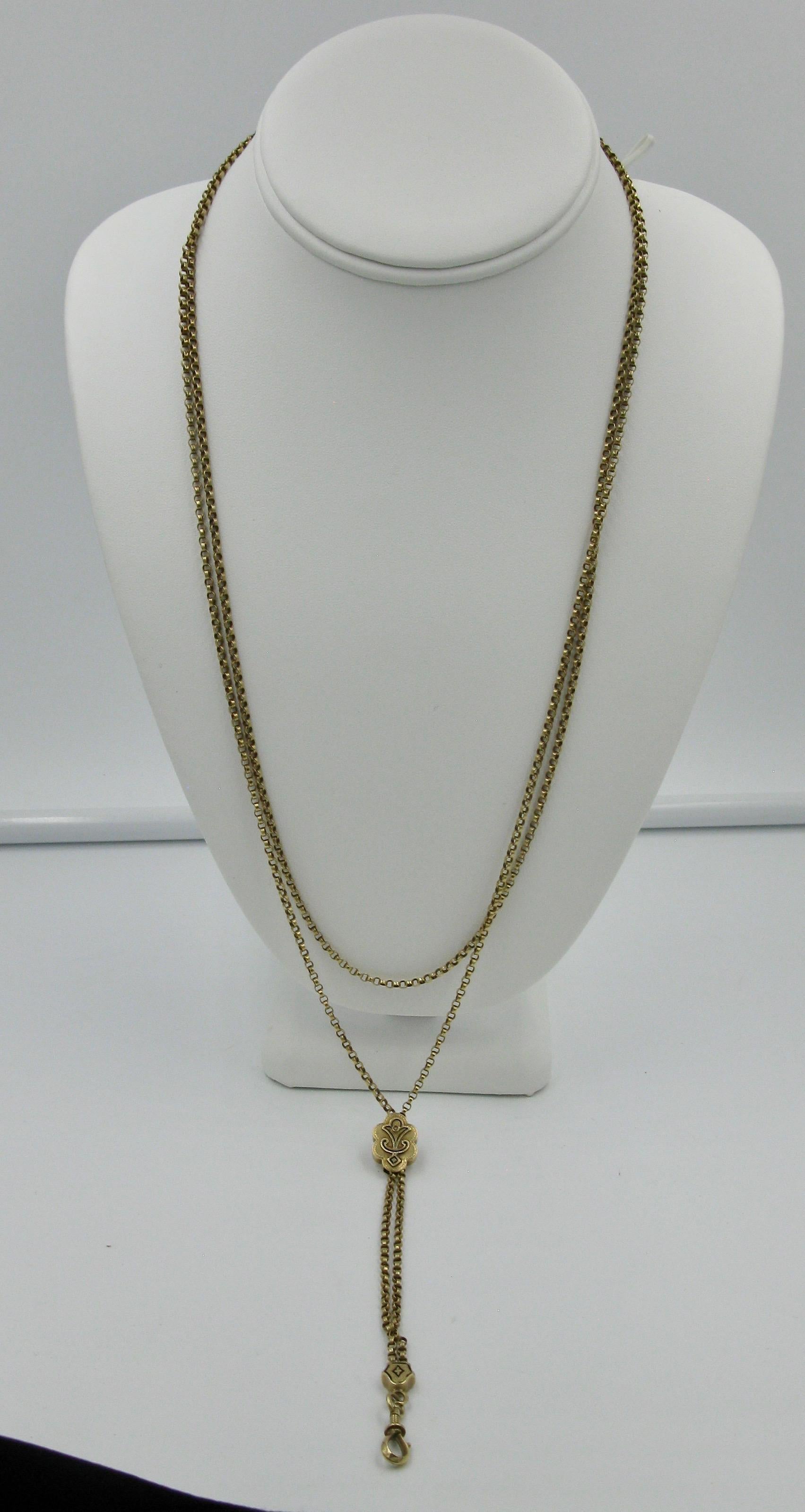 A stunning antique Victorian 56 Inch long 14 Karat Gold Chain Necklace of great beauty.  The chain with an enamel and pearl decorated slide.  At the bottom is a dog clip with a very fine design which opens and closes with a screw design that assures