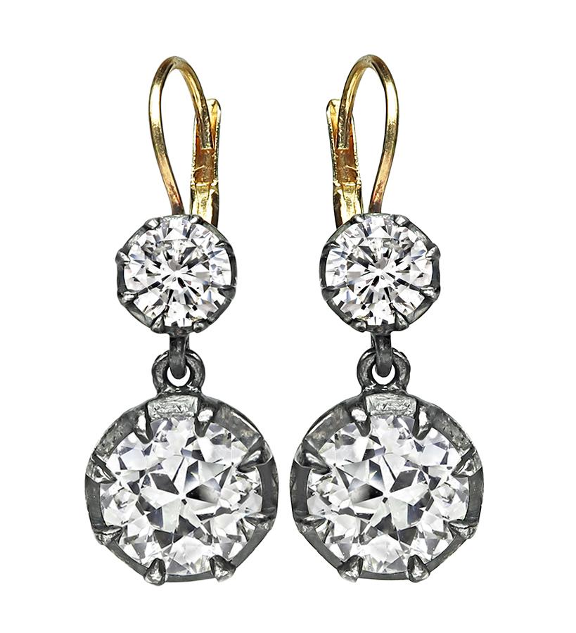 This is a gorgeous pair of silver and gold earrings from the Victorian era. The earrings feature 2 large sparkling old mine cut diamonds that weigh approximately 4.53ct. The color of these diamonds is J-K with VS1 clarity. The diamonds are