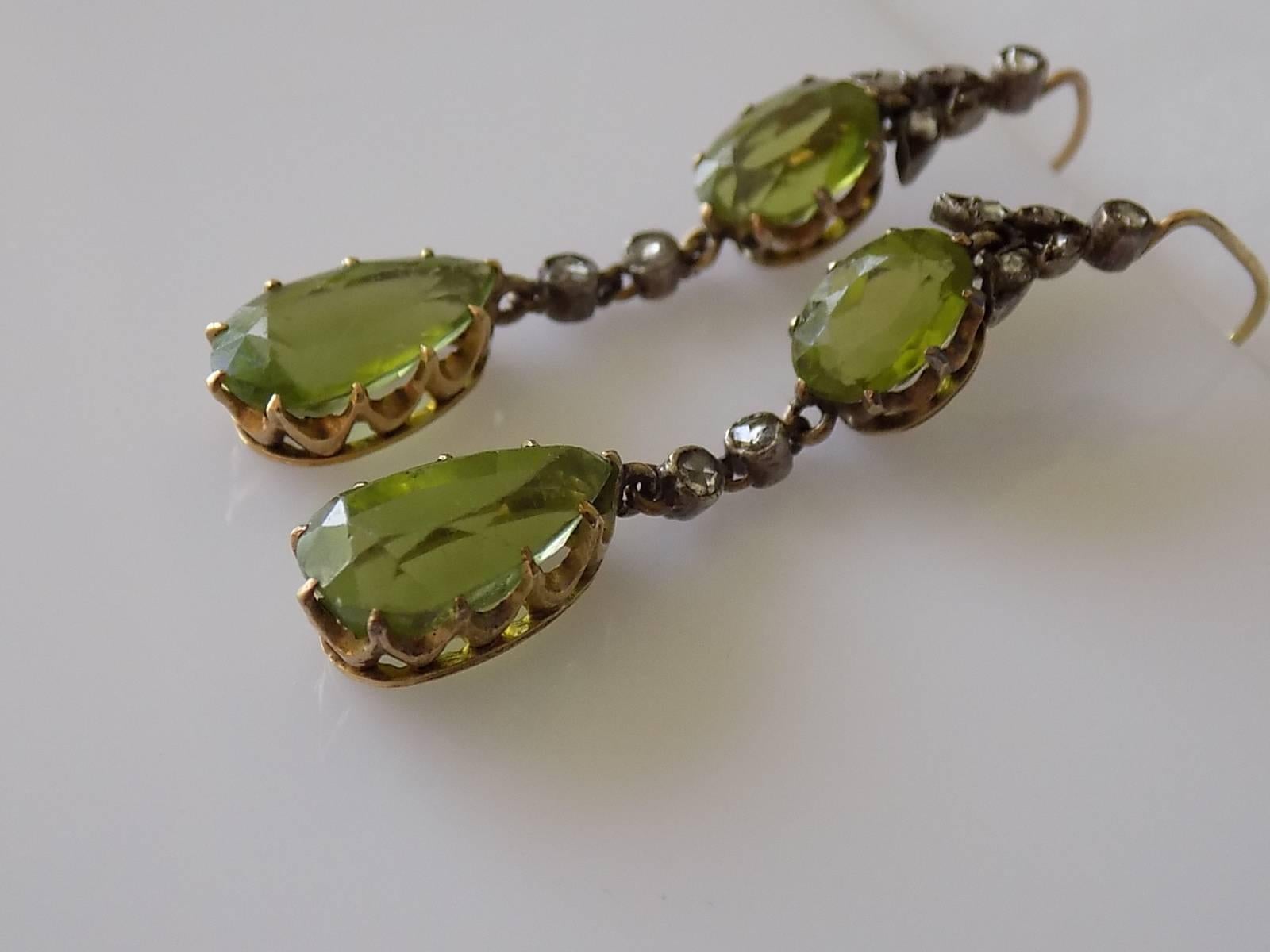 A Spectacular Victorian c.1890 18 Carat Gold and approx. 6.6 Carat Peridot drop earrings with a rose cut diamonds mounted in solid silver. The earrings look outstanding when worn. English origin.
Total Drop including hooks 44mm.
Top Peridots 6.1mm x