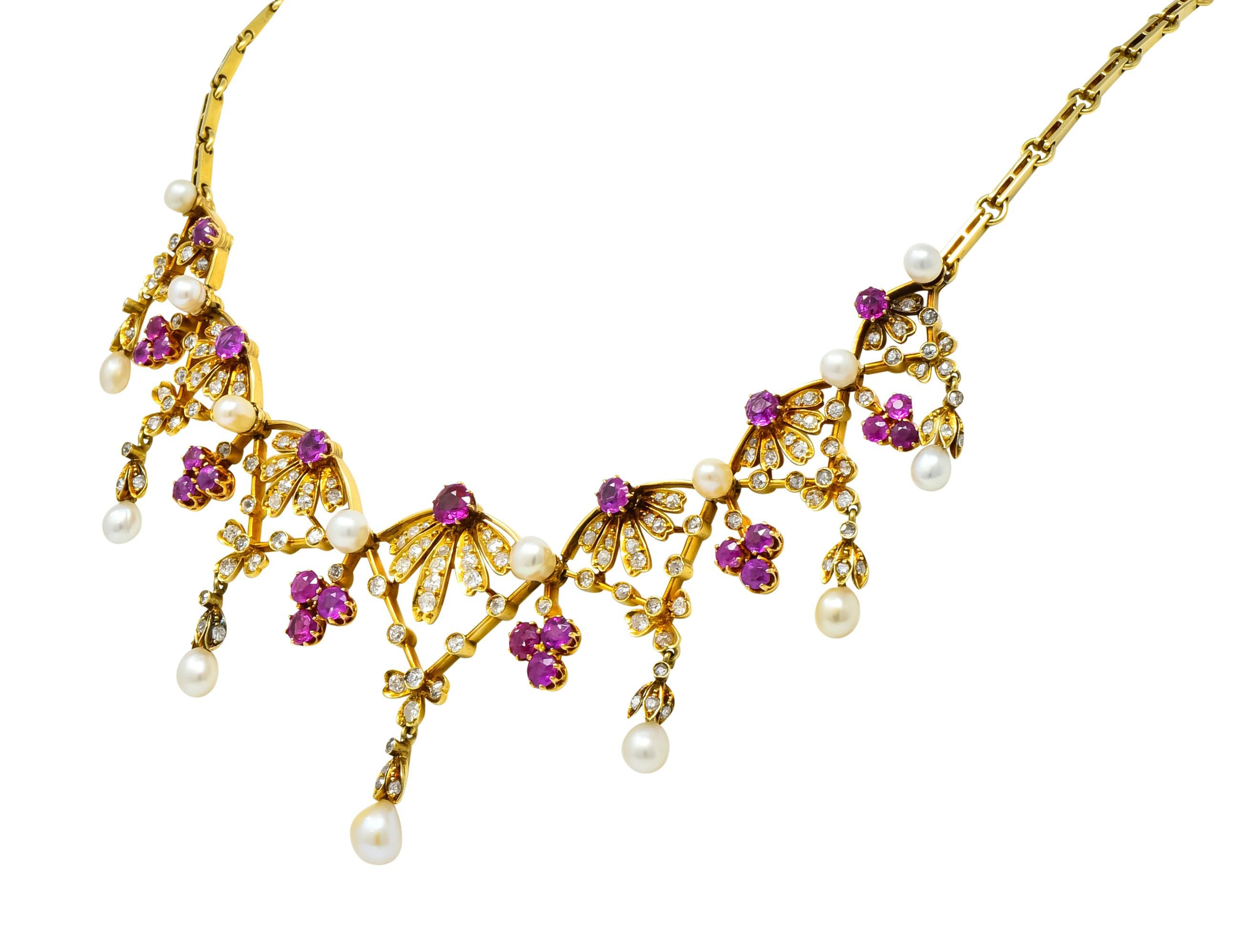 Necklace designed as seven floral stations with bow motif and articulated floral drops

Drops and stations accented by natural freshwater pearls, varying in shape and size, cream in body color with very good luster

With prong set round cut rubies,