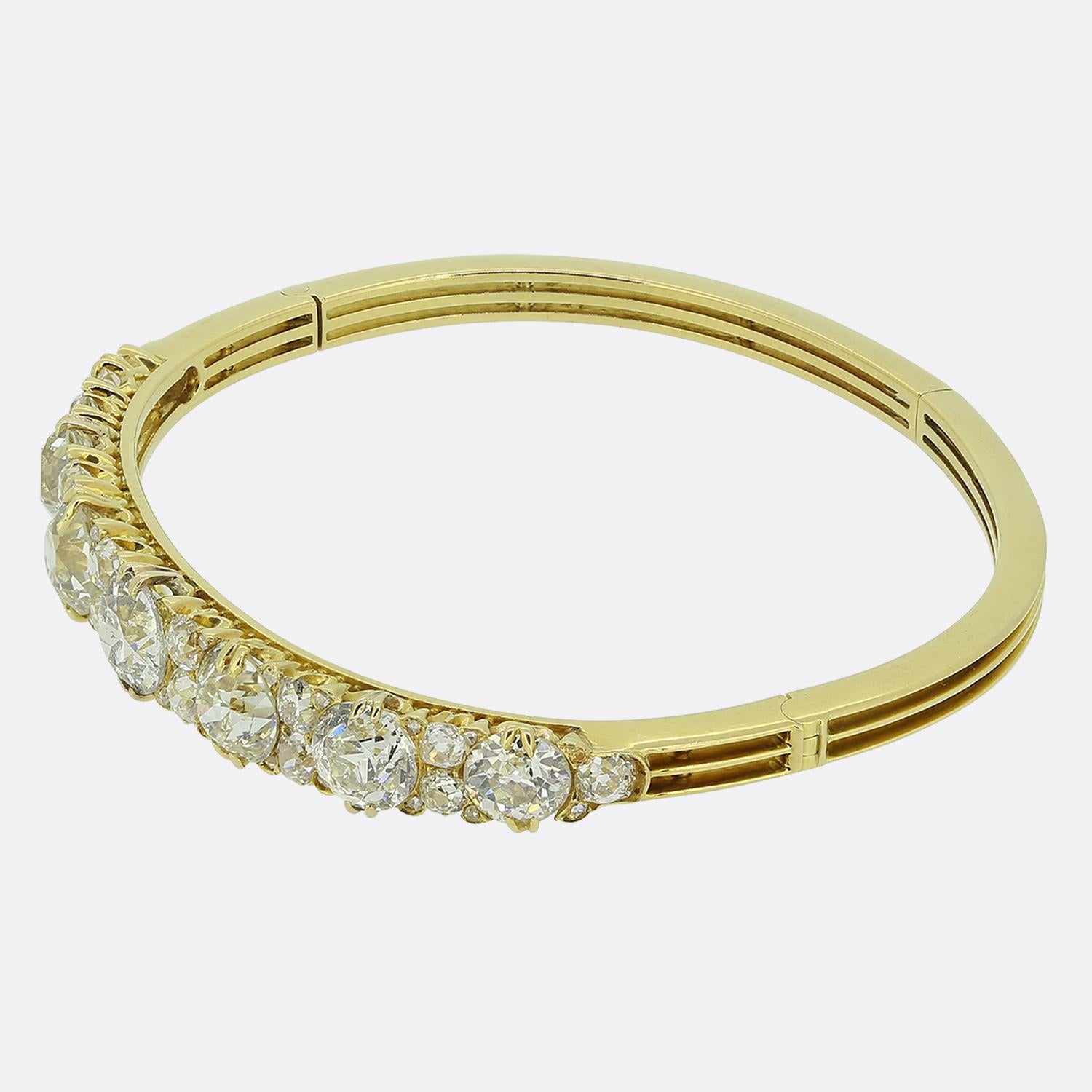 Nous avons ici un merveilleux bracelet serti de diamants datant de la fin de la période victorienne. Cette imposante pièce ancienne a été réalisée en or jaune 18ct et présente sept diamants ronds à facettes de taille ancienne en une seule ligne sur