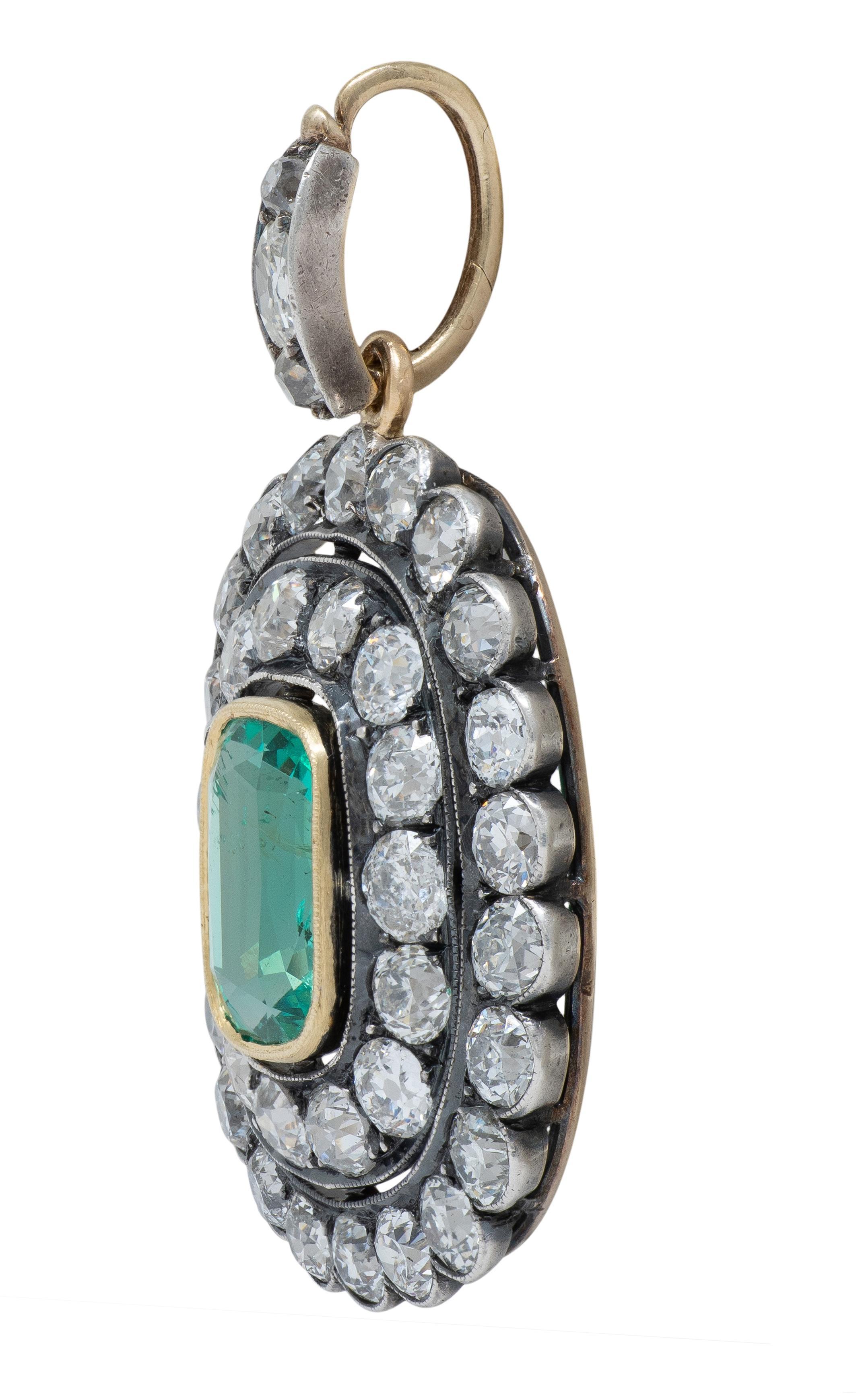 Disegnato come un ciondolo a forma di cuscino sospeso da una balla affusolata e centrato da uno smeraldo.
Peso di circa 8,72 carati - colore verde medio trasparente e vibrante
Incastonato in un castone d'oro con una doppia aureola di diamanti taglio